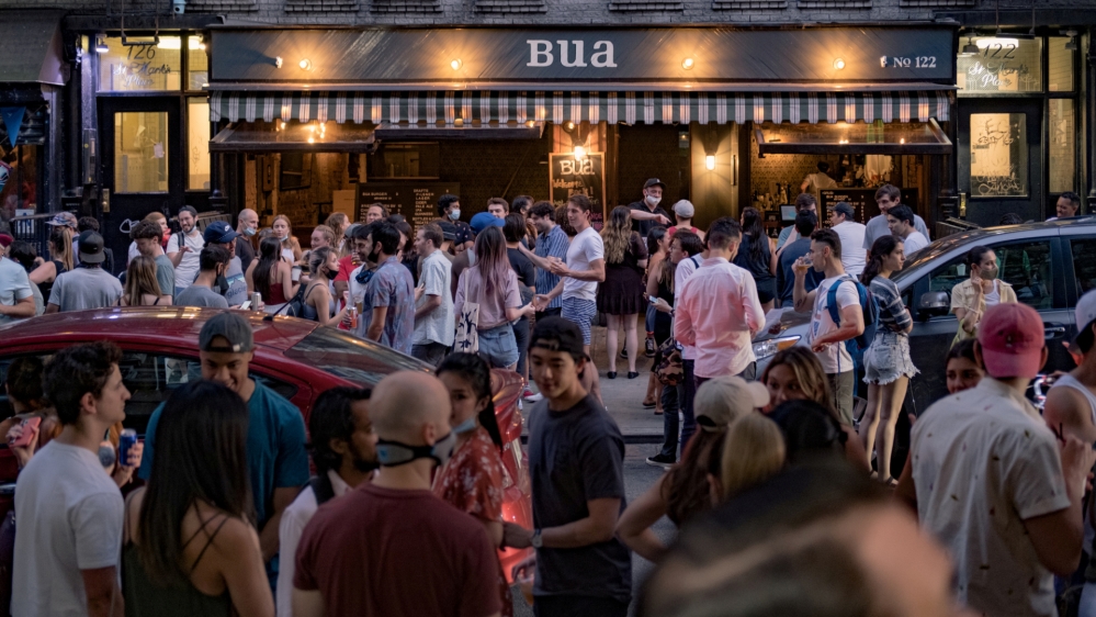 People drink outside a bar during the reopening phase of COVID-19 outbreak in the East Village neighbourhood in New York City, US