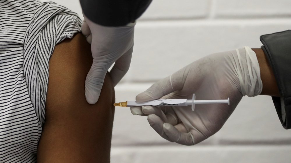 A volunteer receives an injection from a medical worker during the country”s first human clinical trial for a potential vaccine against the novel coronavirus, at the Baragwanath hospital in Soweto, South Africa, June 24, 2020. REUTERS/Siphiwe Sibeko