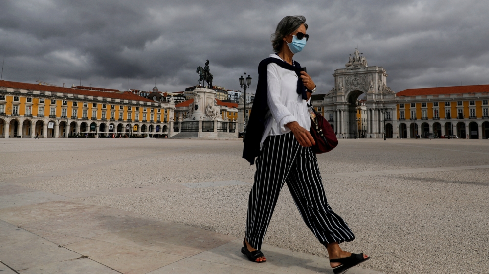 A woman wearing a protective face mask walks at Comercio square, as the outbreak of the coronavirus disease (COVID-19) continues in Lisbon, Portugal, June 26, 2020. REUTERS/Rafael Marchante