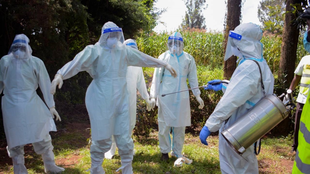 Kenyan health officials wearing personal protection equipment prepare to bury coronavirus victim, Dr Doreen Adisa Lugaliki, in Ndalu, Bungoma county