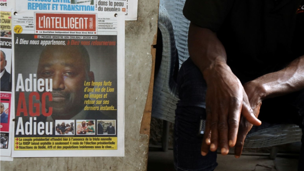 A man sits next to newspapers a day after the death of Ivory Coast''s prime minister Amadou Gon Coulibaly in Abidjan