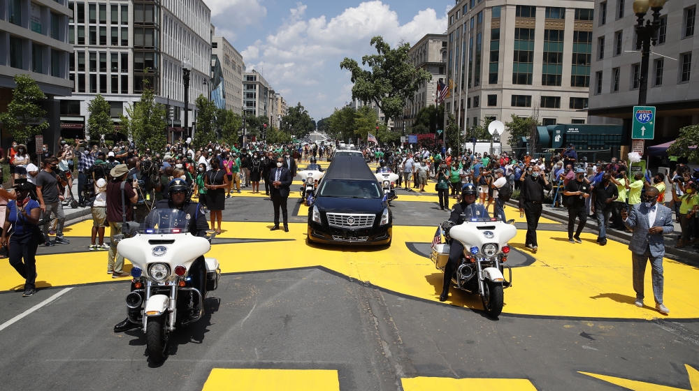 The hearse with the flag-draped casket of Rep. John Lewis, D-Ga., drives on 16th Street, renamed Black Lives Matter Plaza near the White House, Monday, July 27, 2020, in Washington. (AP Photo/Alex Bra