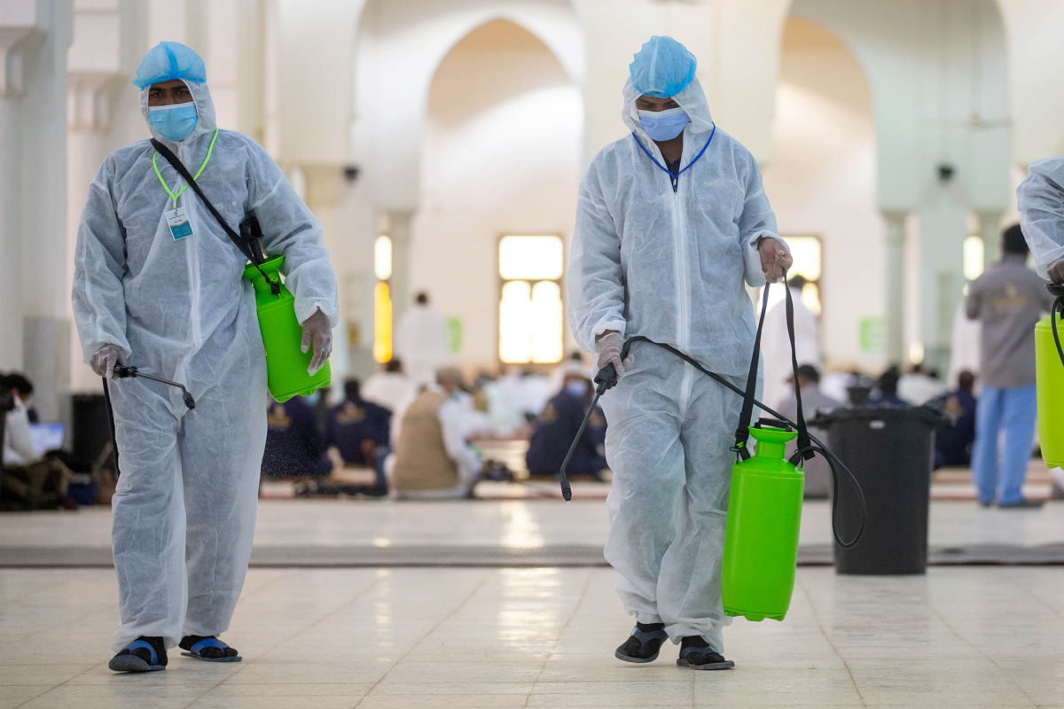Health workers wearing personal protective equipment (PPE) disinfect the floor as Muslim pilgrims pray inside Namira Mosque in Arafat to mark Haj''s most important day, Day of Arafat, during their Haj