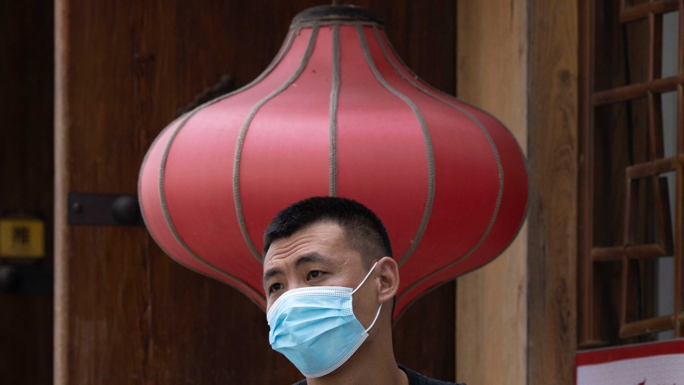 A man wearing a mask outside a restaurant in Beijing