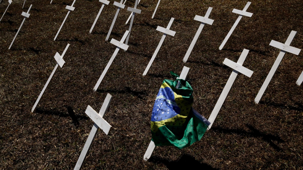 Rows of crosses representing the thousands of deaths due to the new coronavirus are displayed on a lawn during a protest demanding President Jair Bolsonaro be impeached, in front of the National Congress in Brasilia, Brazil
