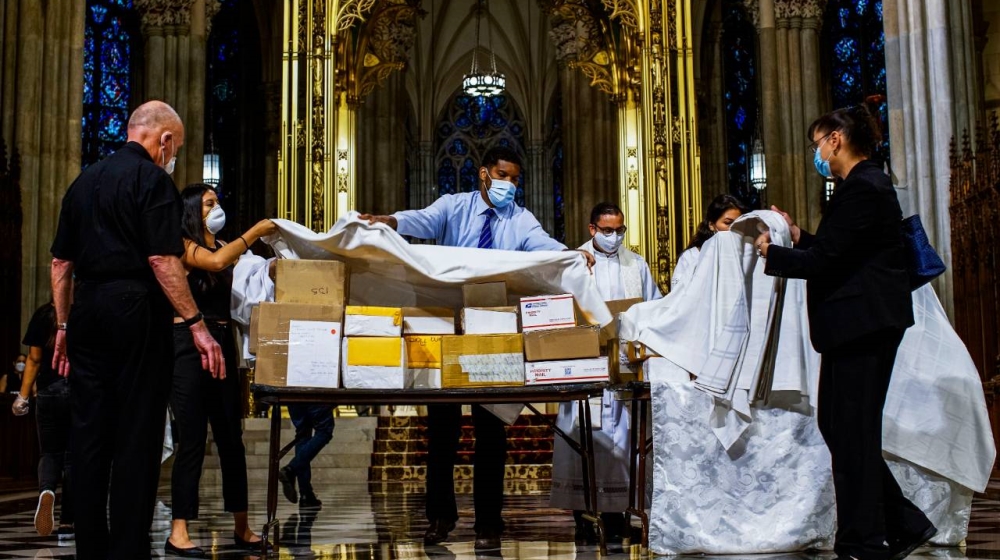 Organisers and church workers cover the boxed cremated remains of Mexicans who died of COVID-19 before a service at St Patrick’s Cathedral in New York on Saturday
