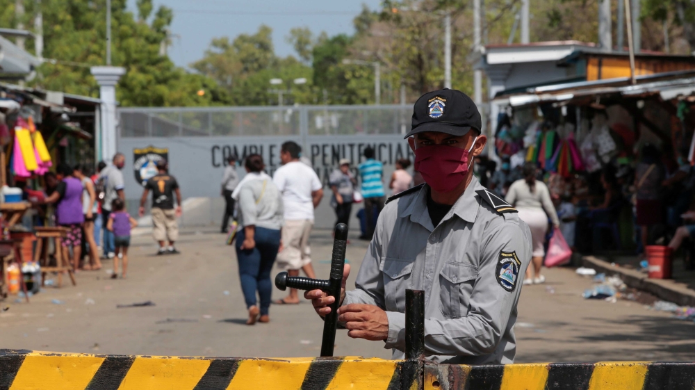 A prison guard stands at the entrance of the penitentiary system "La Modelo"