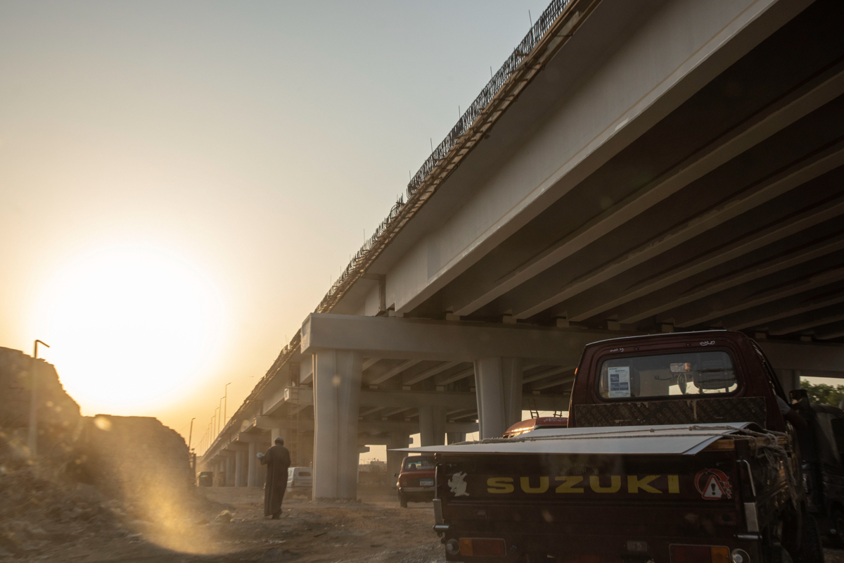 A man walks under a new highway flyover under construction through the Southern Cemetery, part of the City of the Dead, a UNESCO World Heritage Site, in Cairo, Egypt, Tuesday, July 28, 2020. The spraw