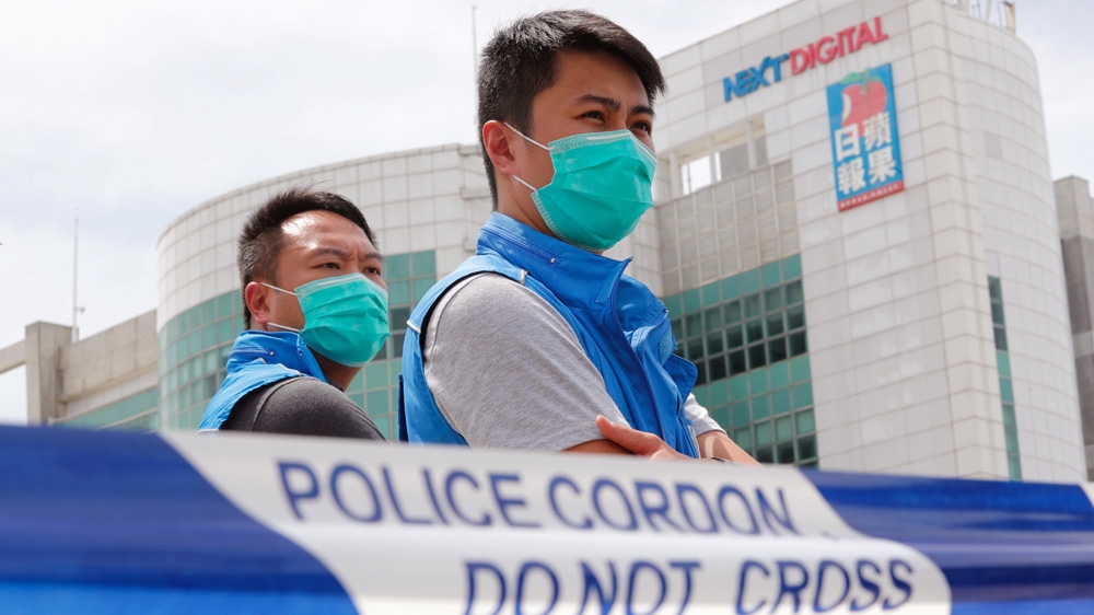Police stand guard outside the headquarters of Apple Daily and Next Media after the Monday arrest of Jimmy Lai when of the territory’s most prominent supporters of democracy