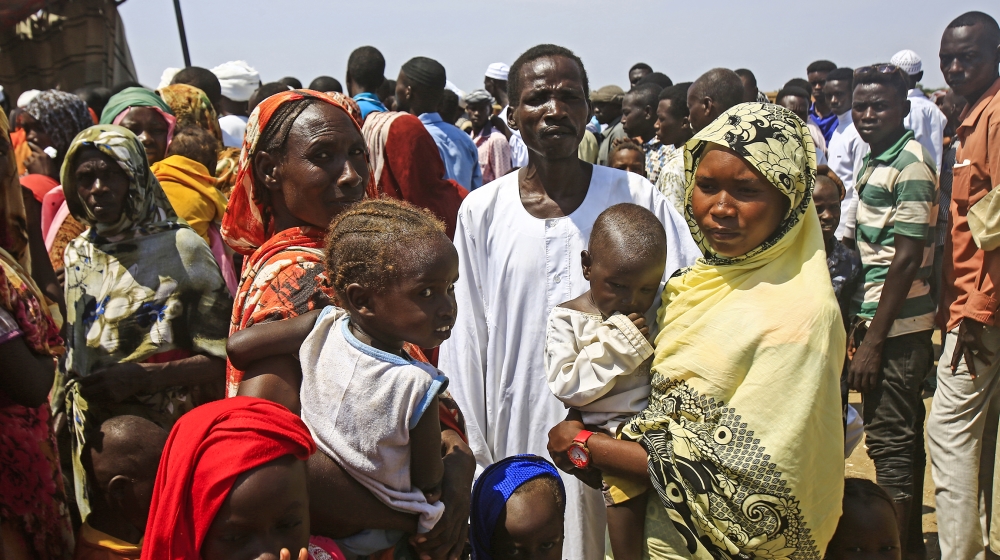 Displaced Sudanese queue to receive humanitarian aid supplies at the Kalma camp for internally displaced people in Darfur''s state capital Niyala on October 9, 2019. The camp hosts about 160,000 people