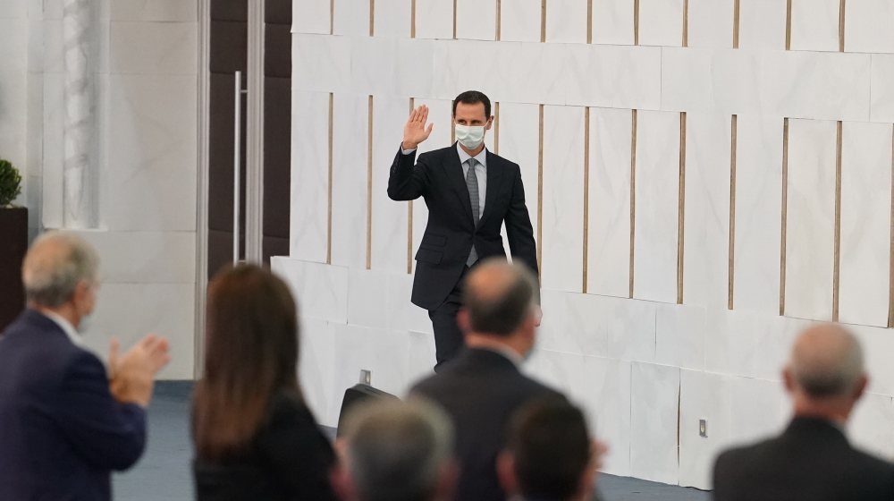 A handout picture released by the official Syrian Arab News Agency (SANA) on August 12, 2020 shows Syrian President Bashar al-Assad greeting members of the People’s Assembly in Damascus. SANA / AFP