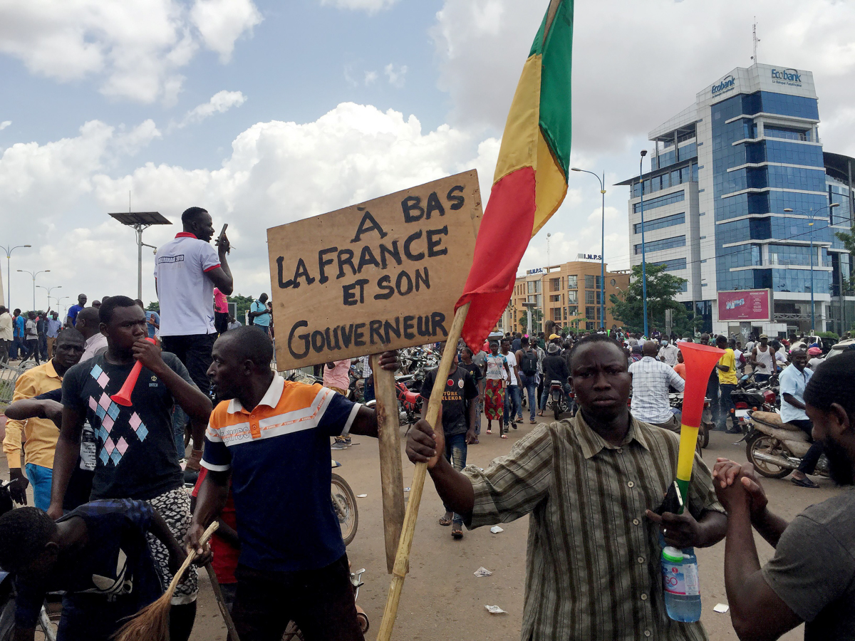 Opposition supporters react to the news of a possible mutiny of soldiers in the military base in Kati, outside the capital Bamako, at Independence Square in Bamako, Mali August 18, 2020. The sign read