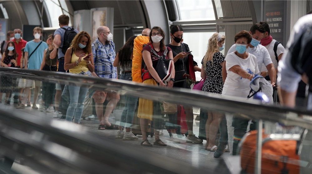 Passengers stand in front of a Coronavirus test center for returnees from risk countries at the international airport in Frankfurt am Main, Germany, 16 August 2020. A coronavirus test has become manda
