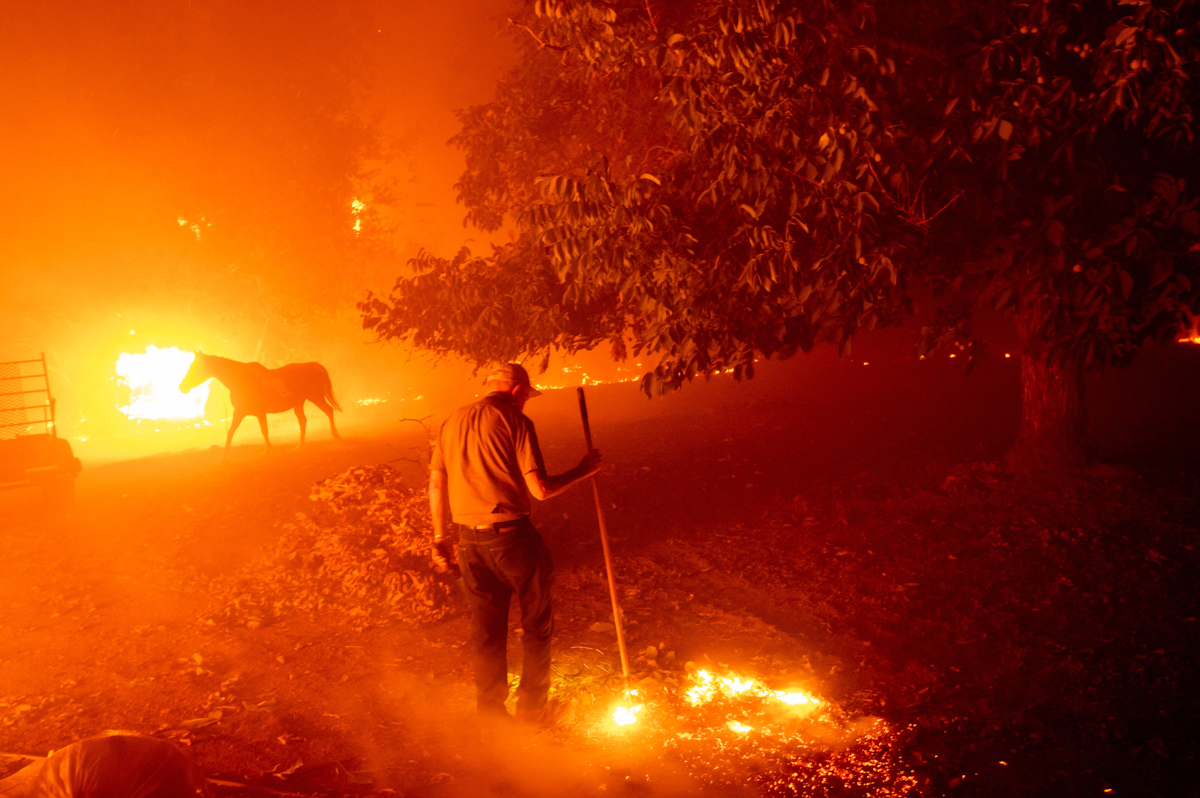 Bill Nichols, 84, works to save his home as the LNU Lightning Complex fires tear through Vacaville, Calif., on Wednesday, Aug. 19, 2020. Nichols has lived in the home for 77 years. Fire crews across t