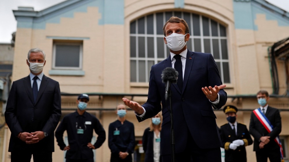French President Emmanuel Macron, wearing a protective face mask, delivers a speech as he visits a site of pharmaceutical group Seqens, a global leader on the production of active 