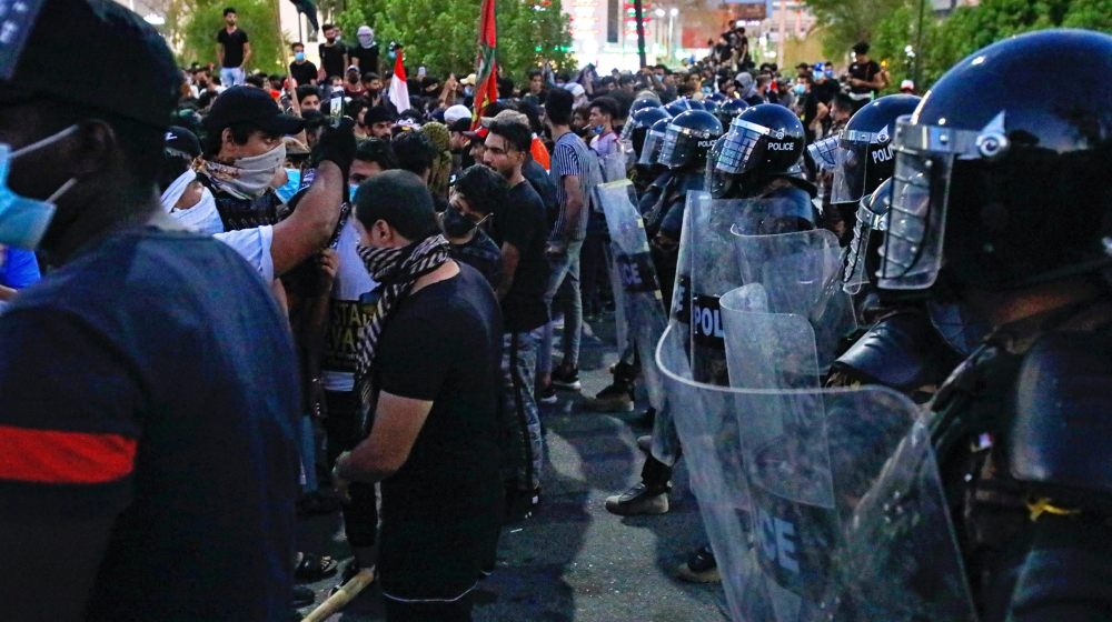 Riot police try to prevent protesters from storming the Iraqi Parliament Building during protests in Basra, Iraq, Friday, Aug. 21, 2020. Demonstrators burned the outer gate of the entrance to the parl