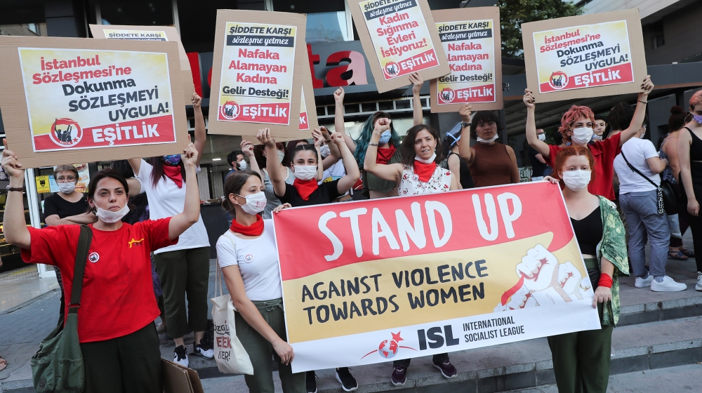 Women wearing face masks hold signs in Ankara, on August 5, 2020, during a demonstration to demand the government does not withdraw from the Istanbul Conventio, a landmark treaty, on preventing domest
