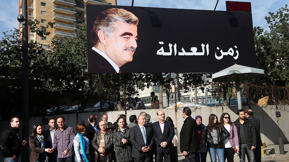 Supporters of slain former Lebanese Prime Minister Rafik Hariri, gather under a giant billboard with his portrait and Arabic that reads, "time for justice," a few hundred of meters (yards) from the si