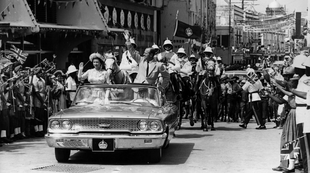 18th February 1966: The Queen and Prince Philip driving through Barbados waving to the crowds. (Photo by Keystone/Getty Images)