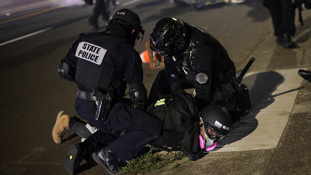 Police detain a demonstrator on the 100th consecutive night of protests against police violence and racial inequality, in Portland, Oregon, U.S. September 5, 2020. REUTERS/Carlos Barria