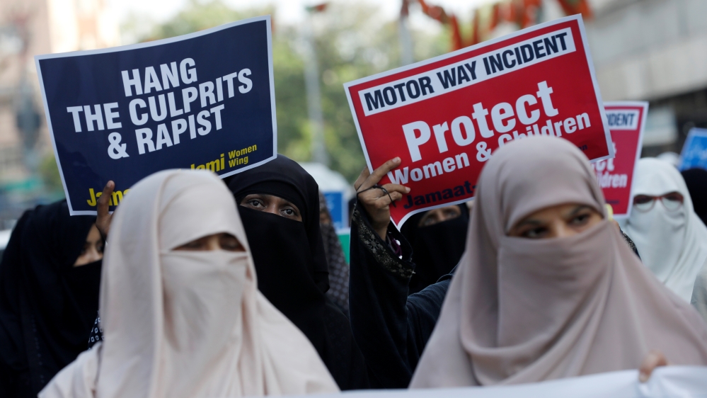 People carry signs to condemn the violence against women and girls, during a demonstration in Karachi