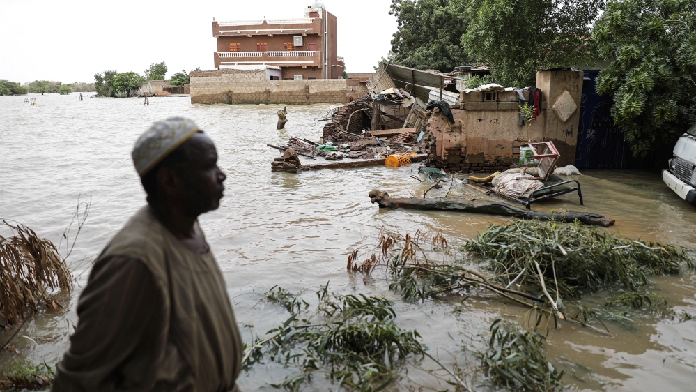 A man walks beside a flooded road in the town of Shaqilab, about 15 miles (24 kilometers) southwest of the capital, Khartoum, Sudan, Monday, Aug. 31, 2020. (AP Photo/Marwan Ali)