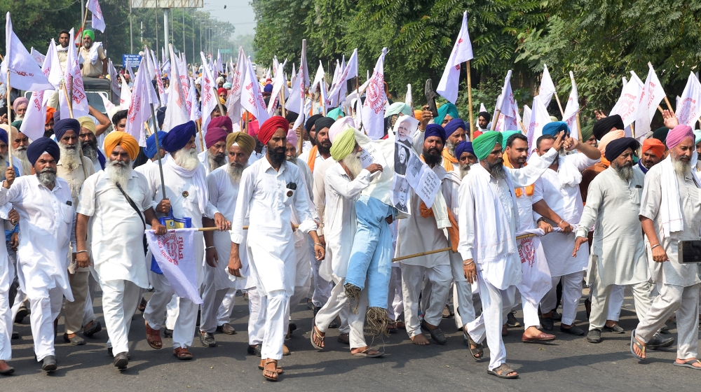 Farmers shout slogans as they march to burn an effigy of India's Prime Minister Narendra Modi and Union Agriculture Minister Narendra Singh Tomar, following the passing of agriculture bills in the Lok