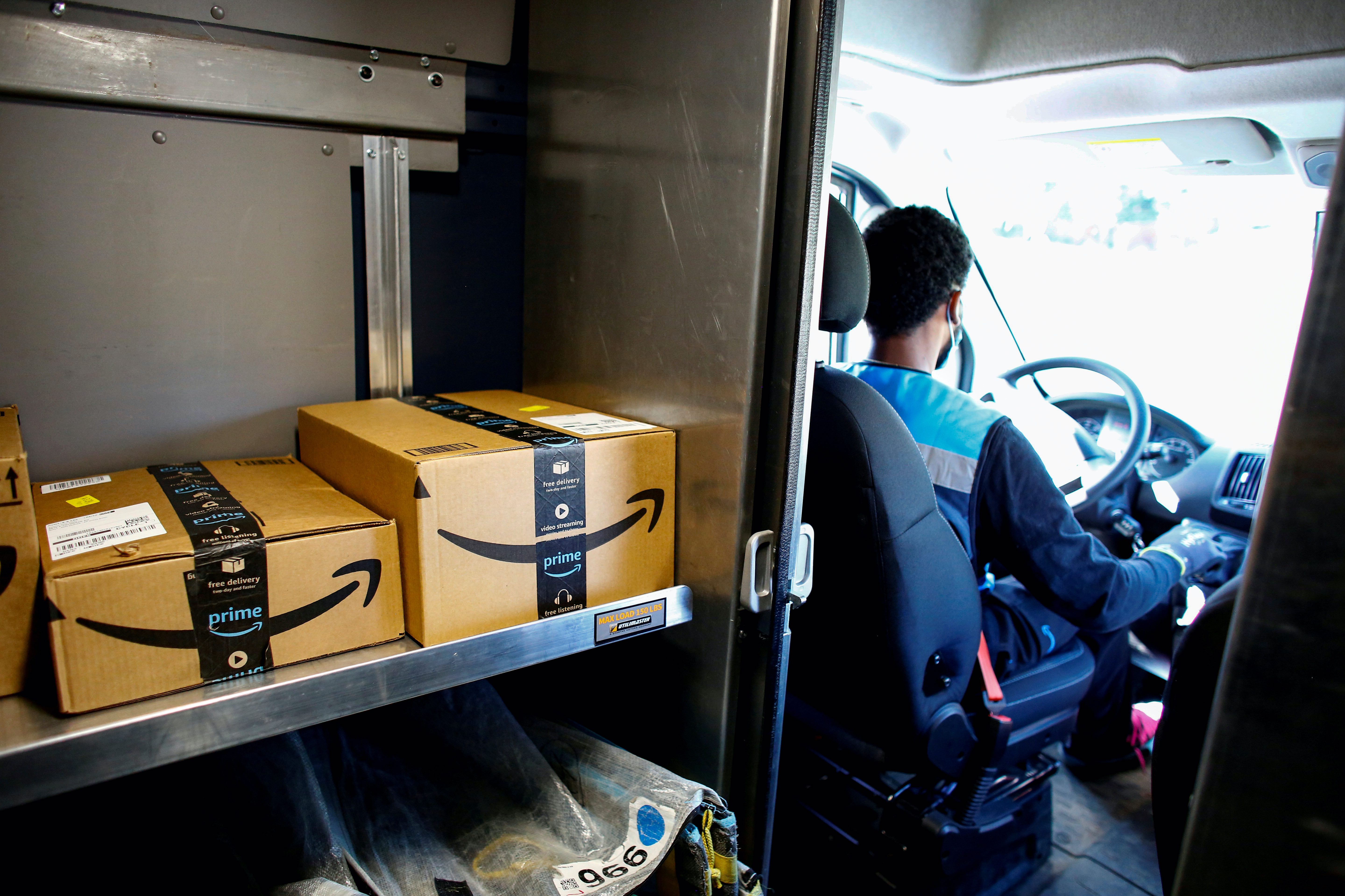 An Amazon worker delivers packages in Denver, Colorado, US, on April 22, 2020 [Kevin Mohatt/Reuters]