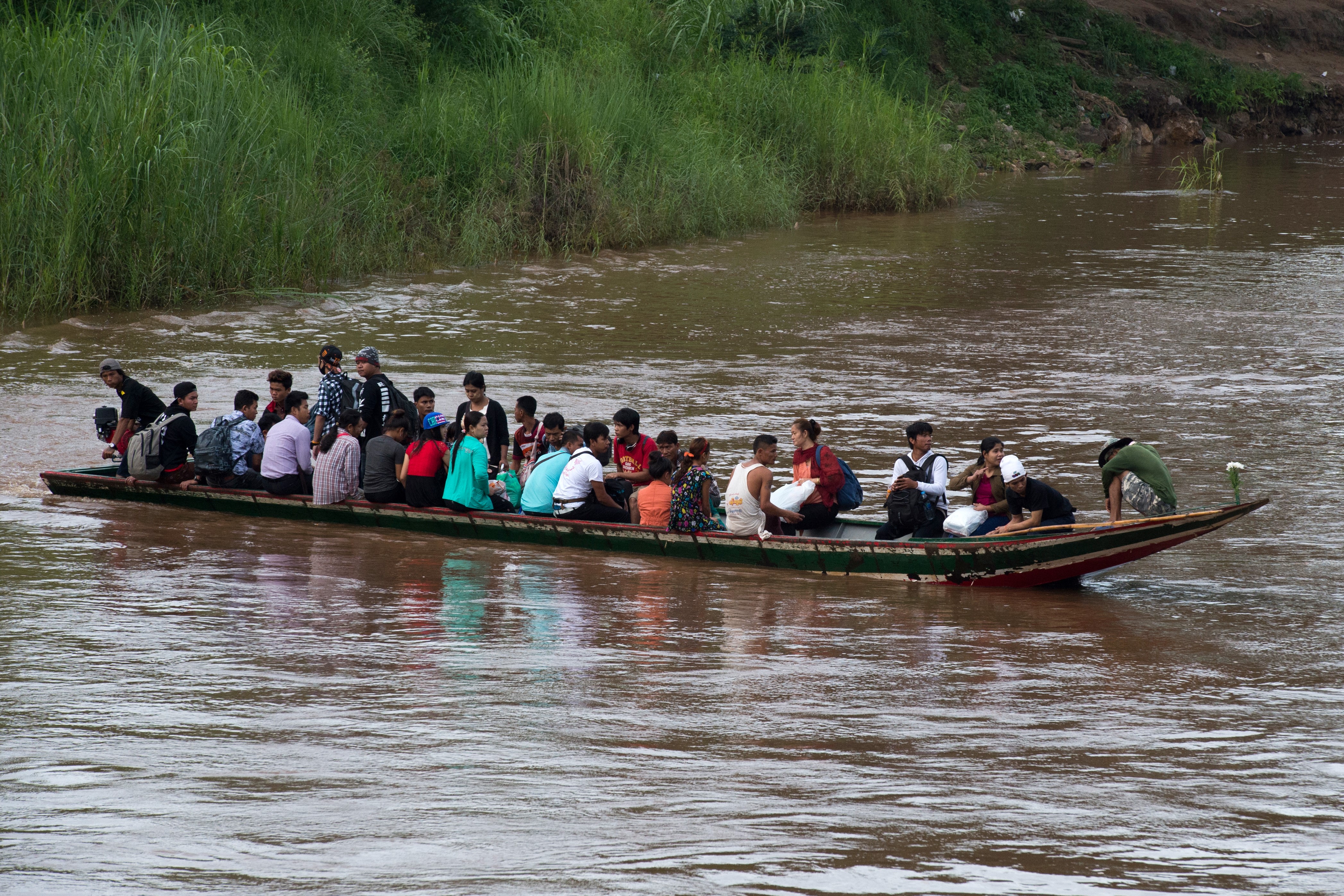 Migrant workers cross the border between Thailand and Myanmar in a boat in the Moei River near Mae Sot, in northern Thailand on July 7, 2017 [File: AFP/Ye Aung Thu]