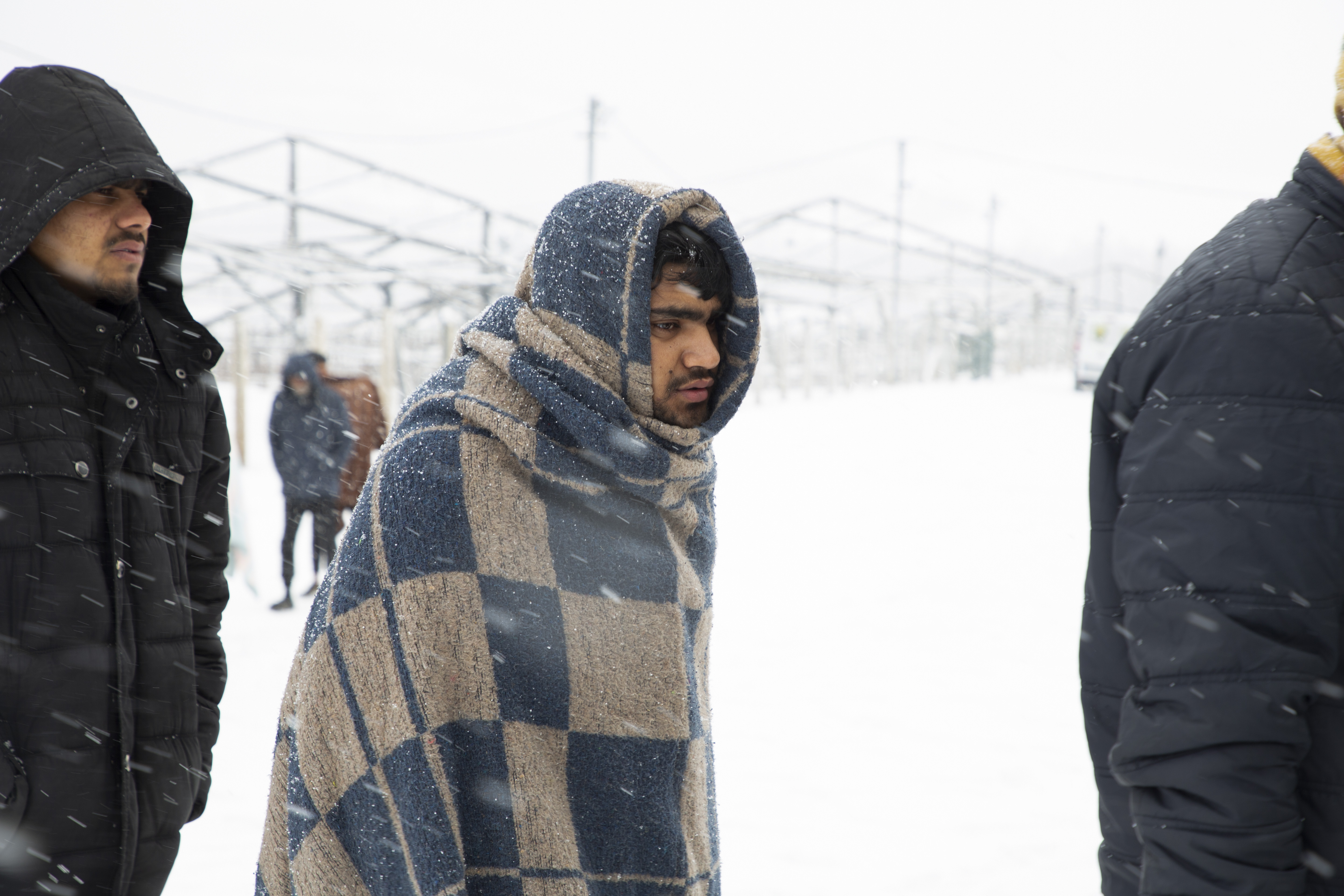 A young man lines up for food in the Lipa refugee camp [Elisa Oddone/Al Jazeera]
