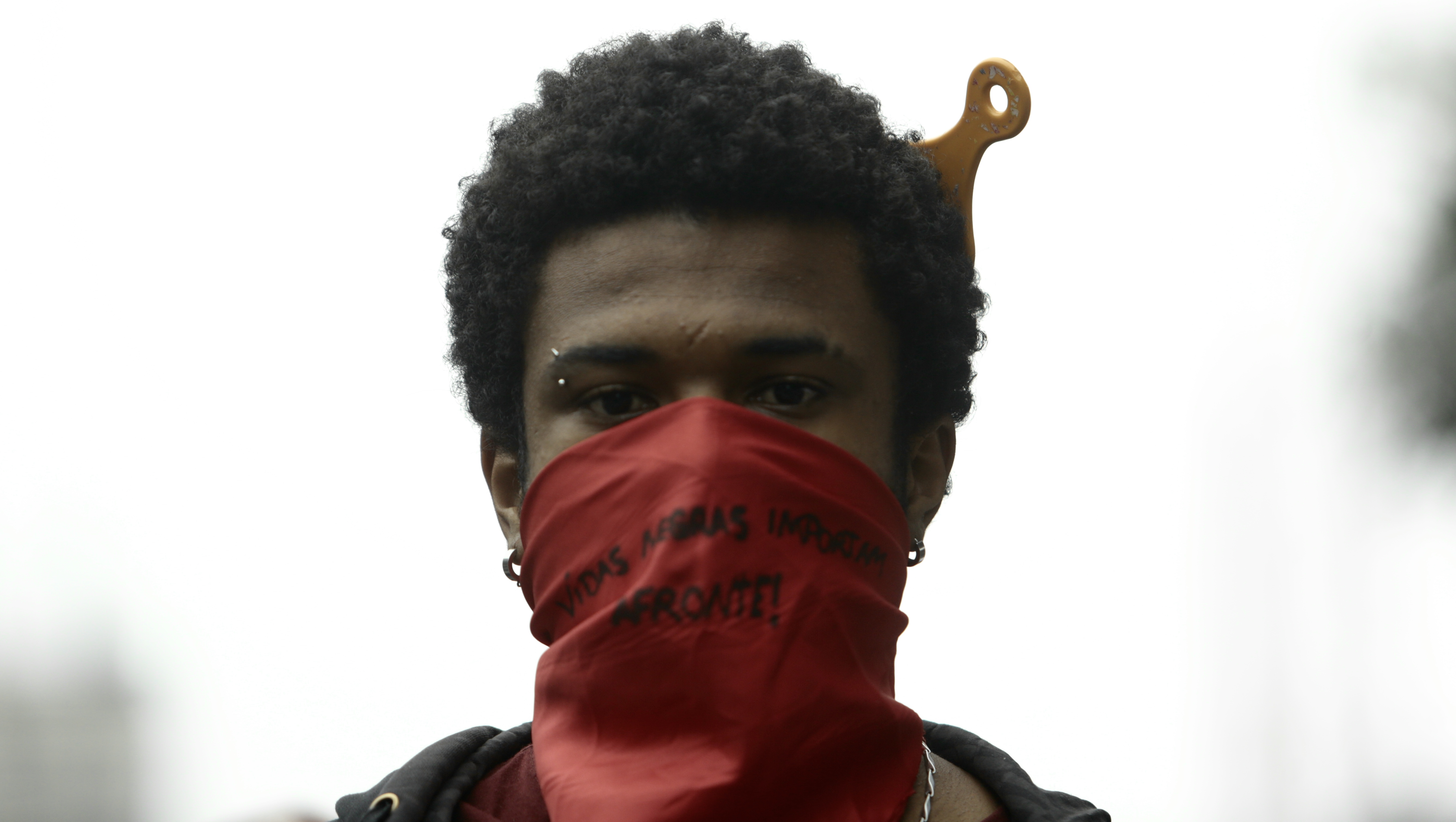 A protester wearing a face mask that reads "Black Lives Matter" looks on at Paulista Avenue during a protest amidst the coronavirus (COVID-19) pandemic on June 14, 2020 in Sao Paulo, Brazil. [Miguel Schincariol/Getty Images]