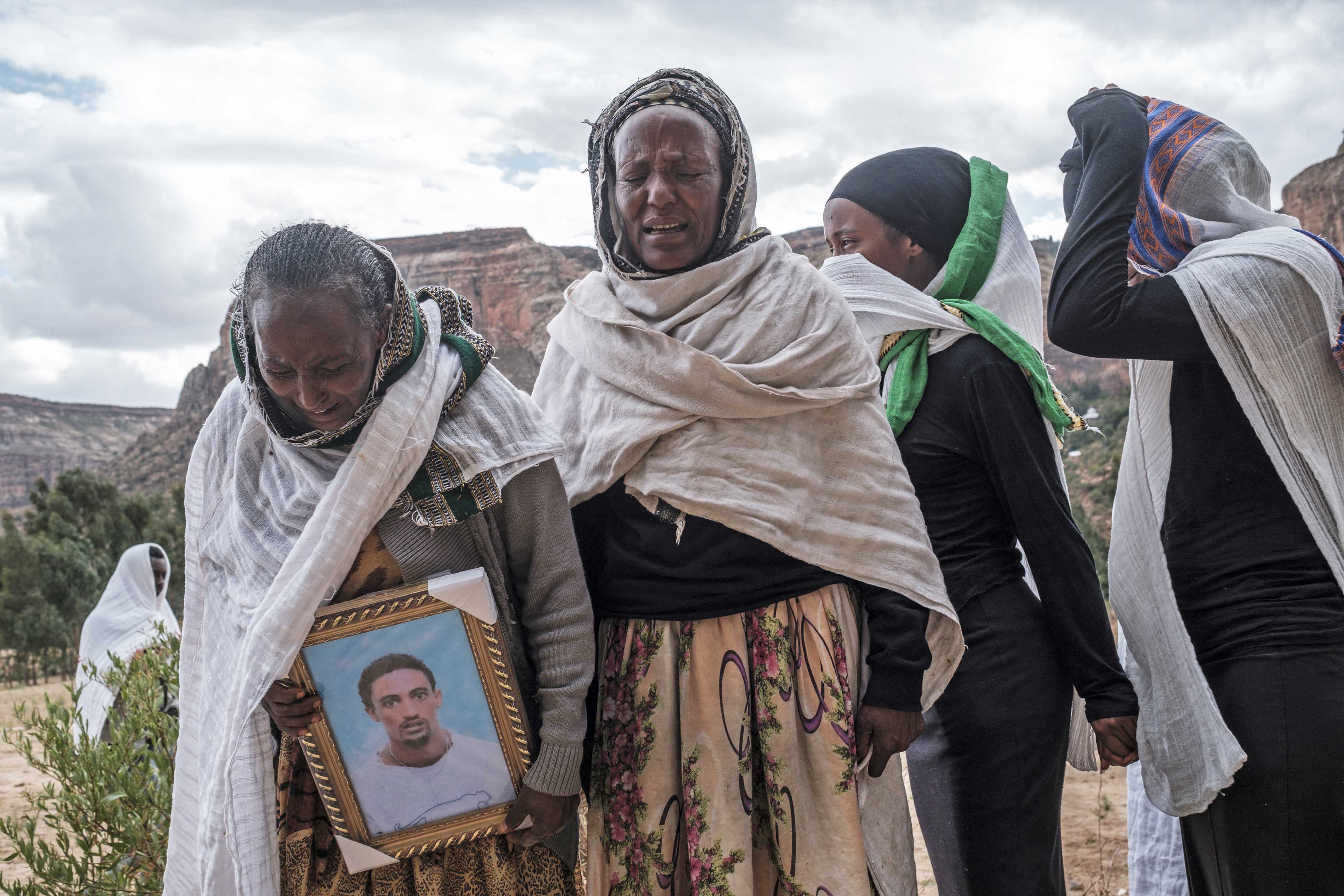 People gather to mourn the victims of a massacre allegedly perpetrated by Eritrean soldiers in the village of Dengolat in the Tigray region of Ethiopia on February 26, 2021 [File: AFP/Eduardo Soteras]