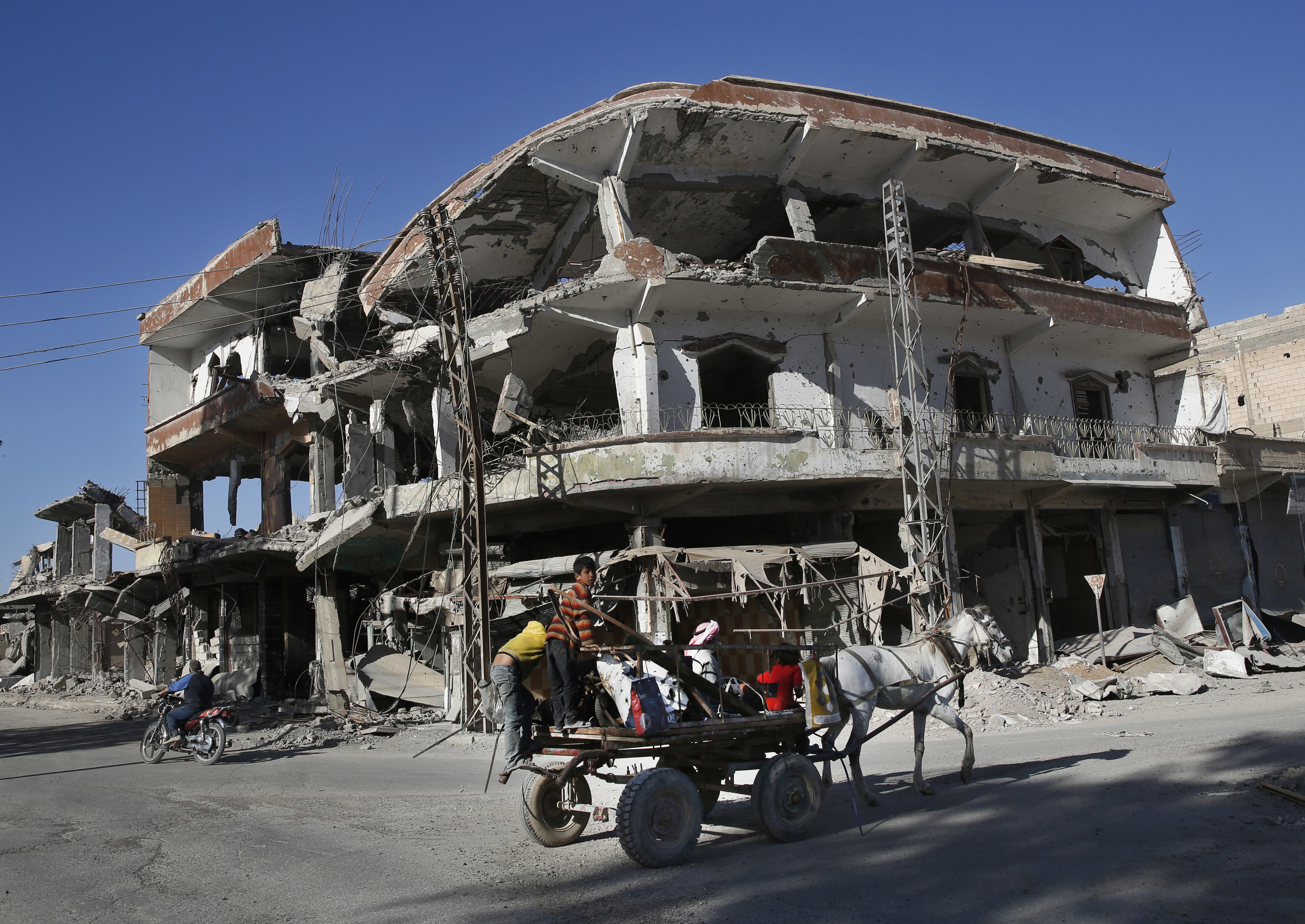 the remains of buildings line a street that was damaged last summer during fighting between U.S.-backed Syrian Democratic Forces fighters and Islamic State militants, in Raqqa, Syria.