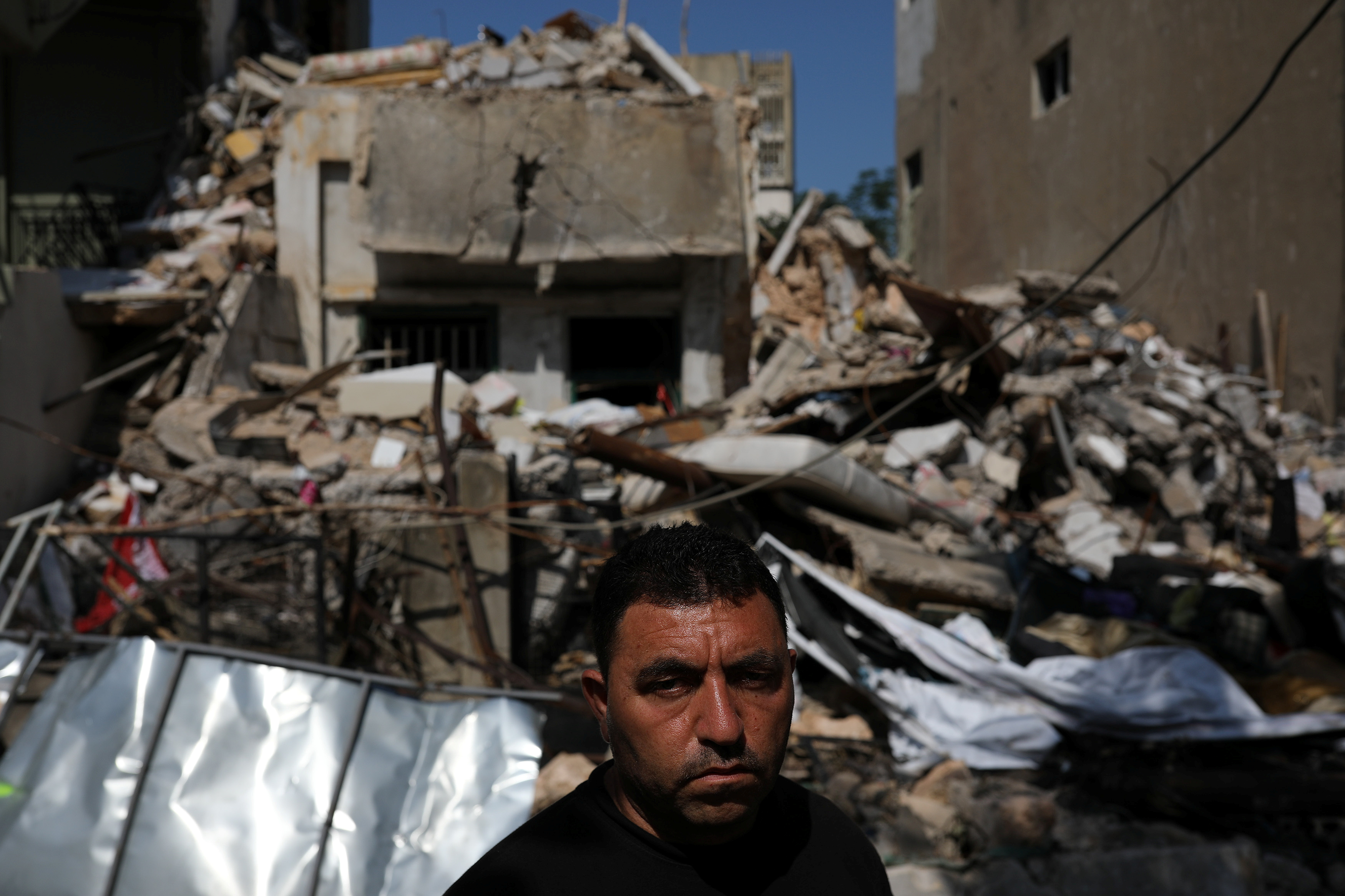 Syrian refugee Ahmed Staifi stands in front of the house where his wife and two daughters were killed in the massive Beirut explosion [File: Alkis Konstantinidis/Reuters]