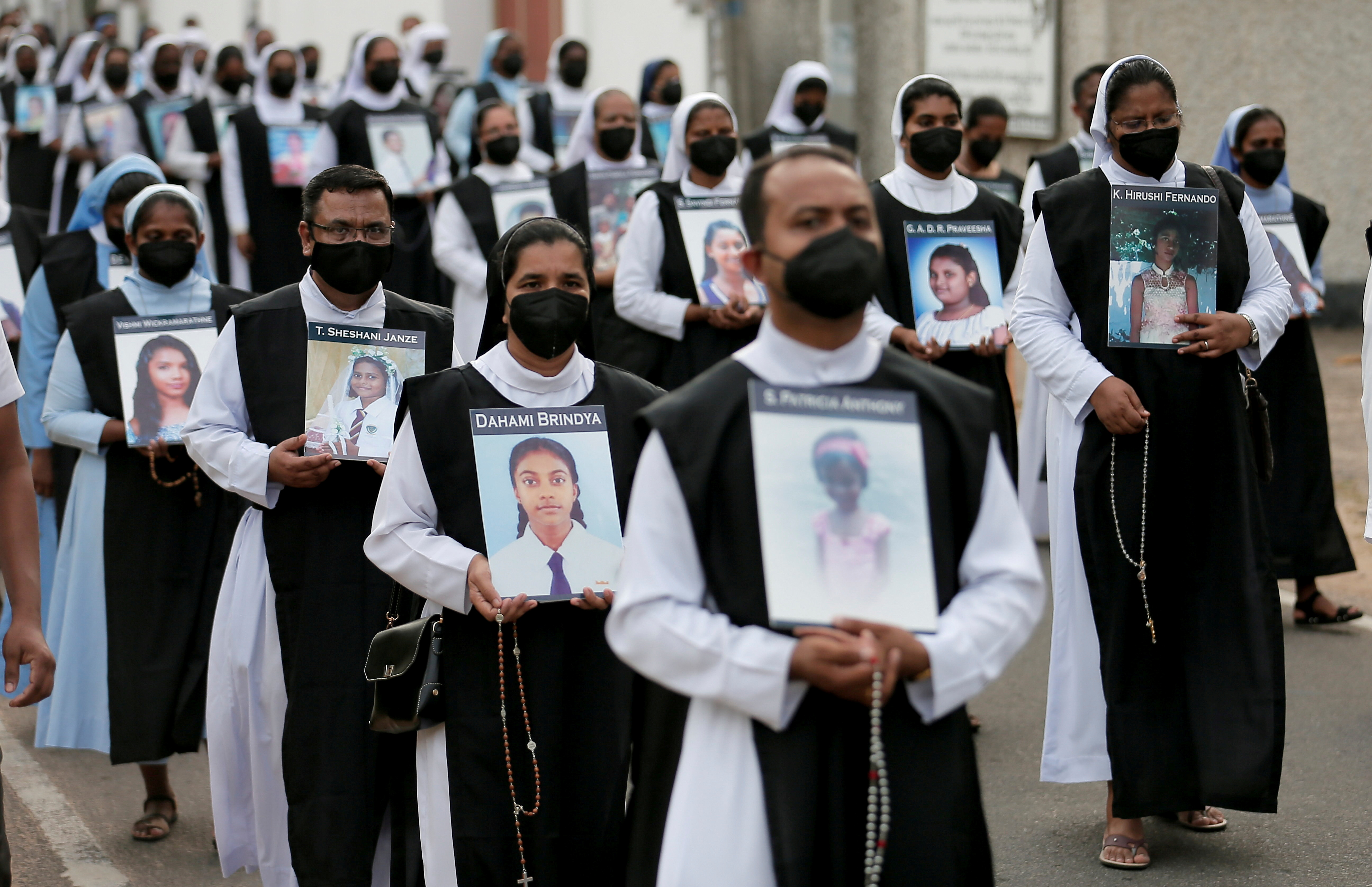 Catholic priests and nuns march while holding images of the victims of the Easter Sunday bombings, next to St. Sebastian's Church in Katuwapitiya, Sri Lanka [File: Dinuka Liyanawatte/Reuters]