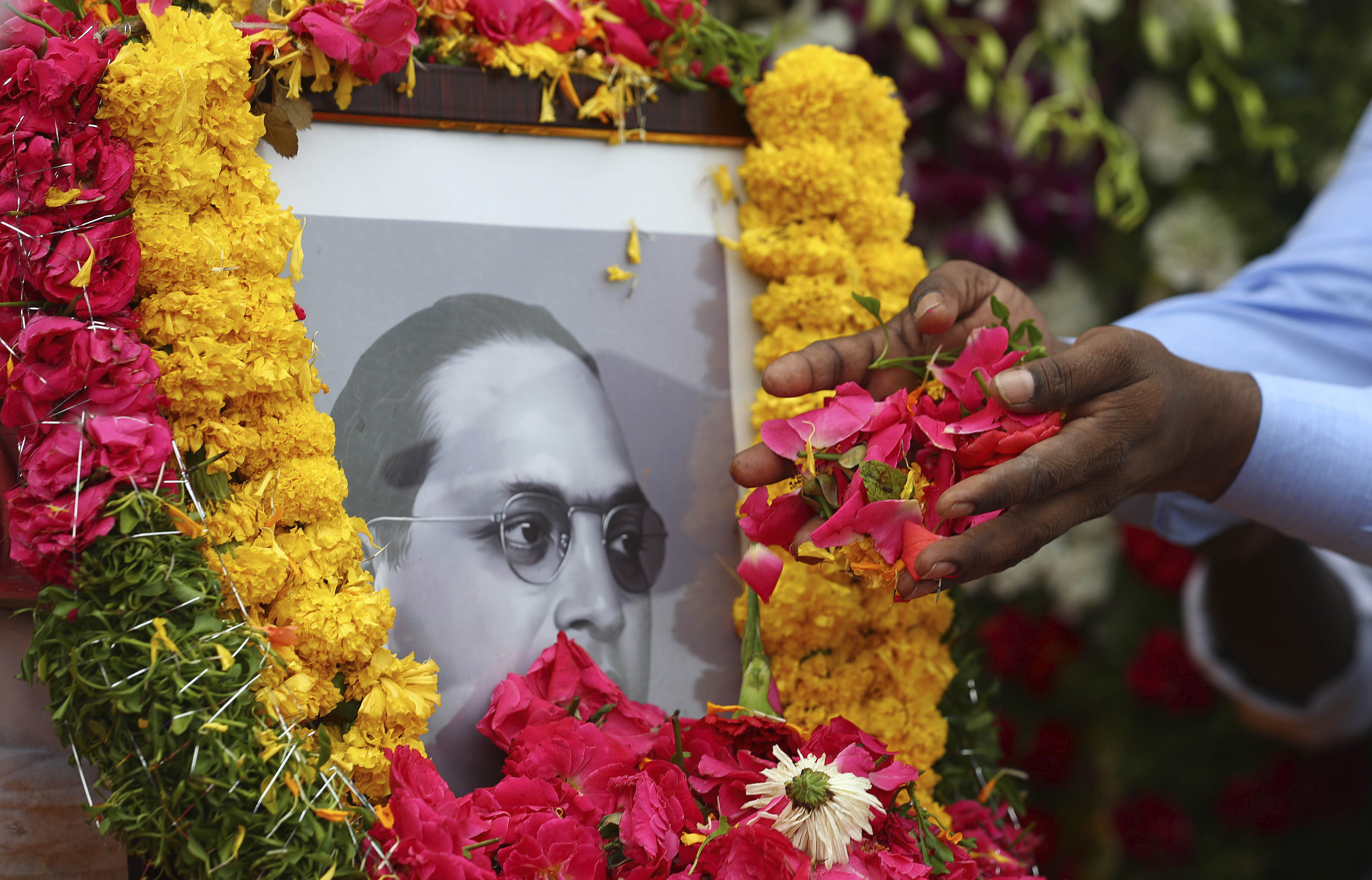 People offer floral tributes to a portrait of Bhimrao Ambedkar on his birth anniversary in Hyderabad, India on April 14, 2021 [AP/Mahesh Kumar A]
