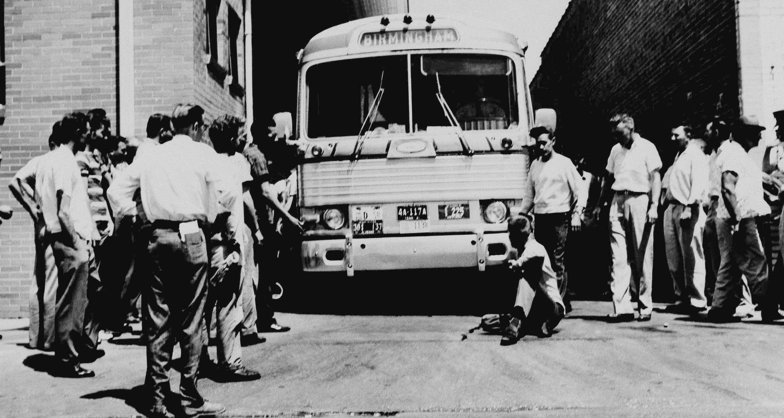 An unidentified white man sitting in front of a Greyhound bus to prevent it from leaving the station with load of Freedom Riders testing bus station segregation in the South, on May 15, 1961, in Anniston, Alabama [File: AP Photo]