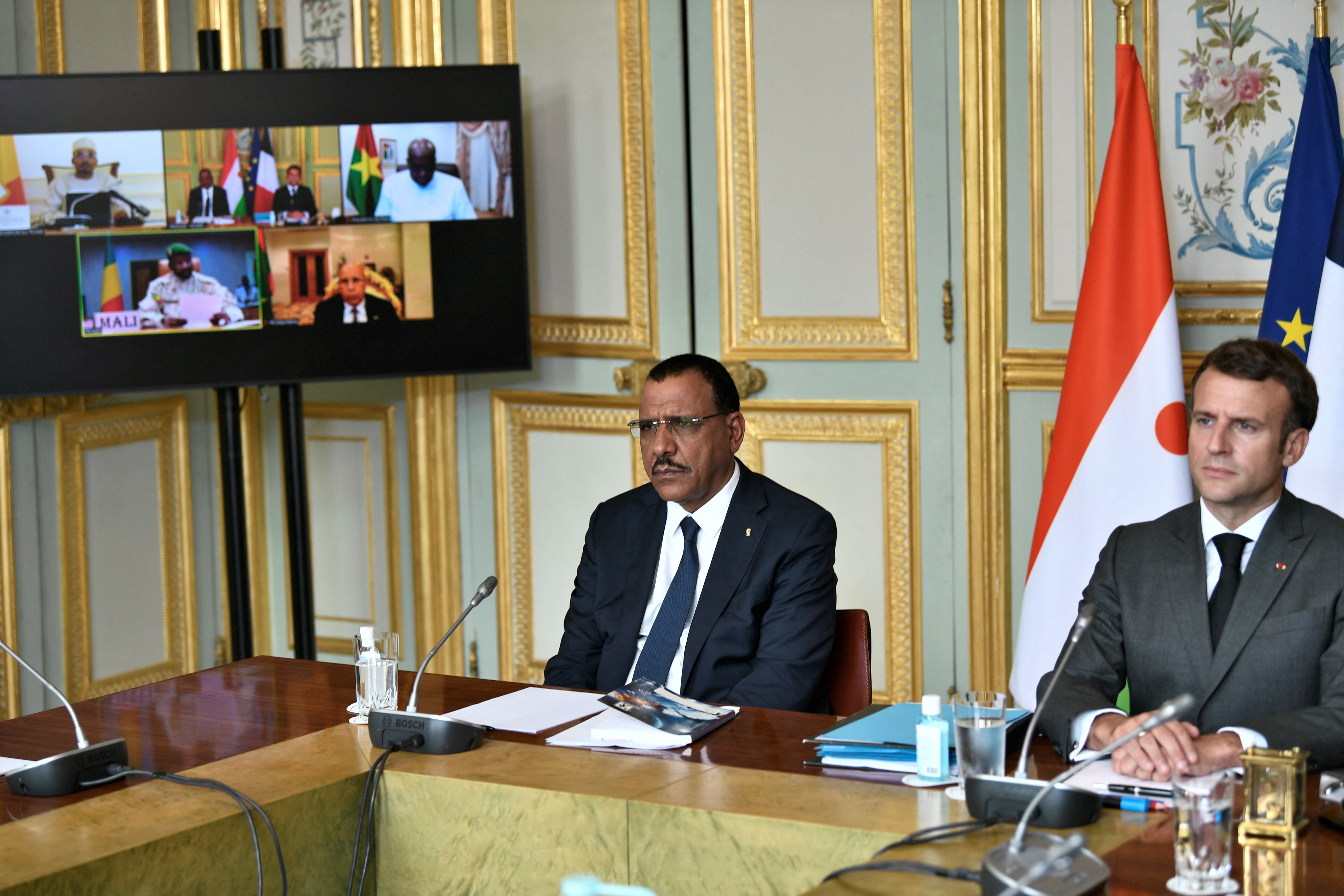 French President Emmanuel Macron (R) and Niger's President Mohamed Bazoum (L) wait for the start of a video summit with leaders of G5 Sahel countries after France's decision last month to reduce French anti-terror troops in West Africa, at the Elysee presidential Palace in Paris