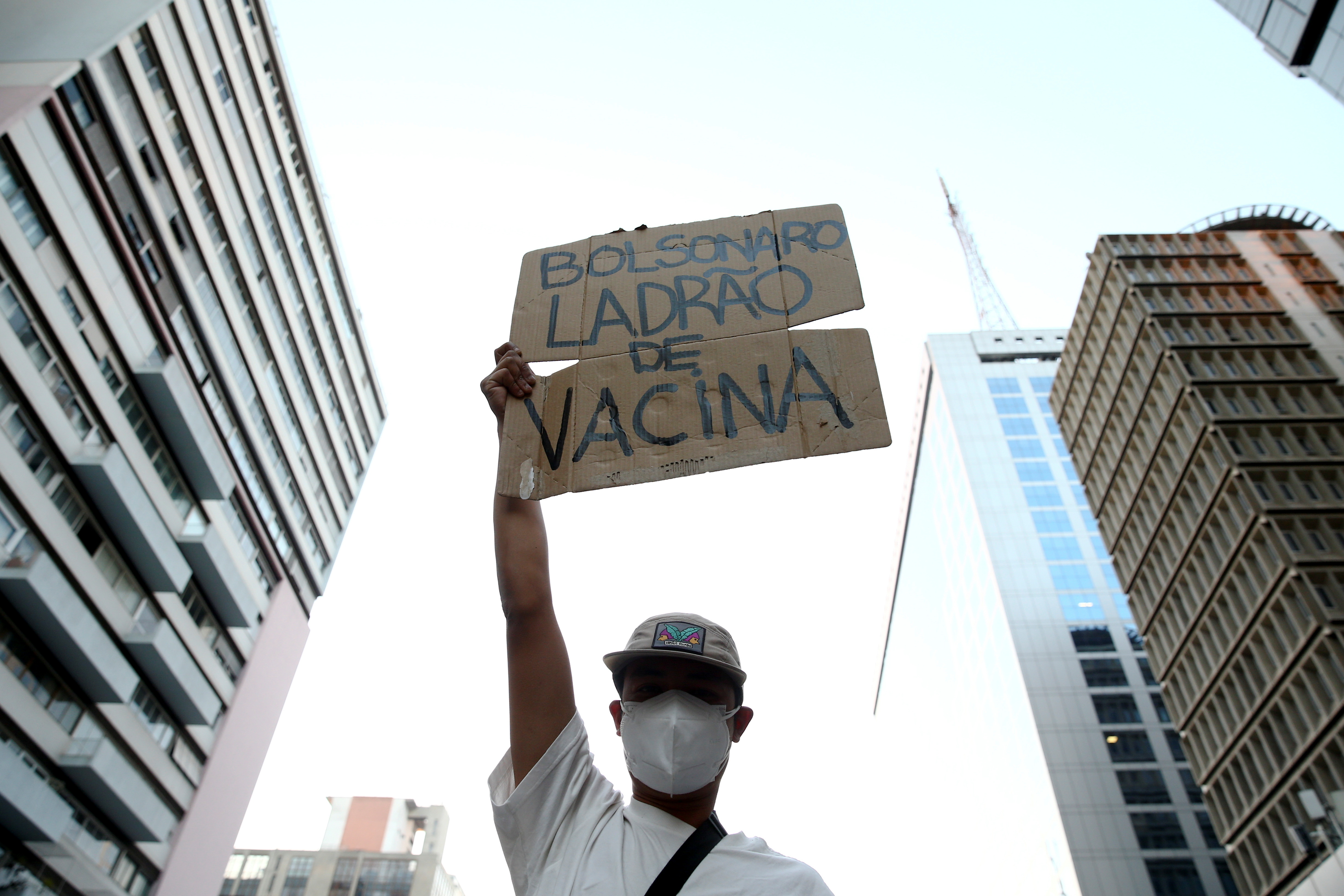 A man displays a sign that reads ‘Bolsonaro vaccine thief’ during a protest against Brazil’s President Jair Bolsonaro in Sao Paulo, Brazil