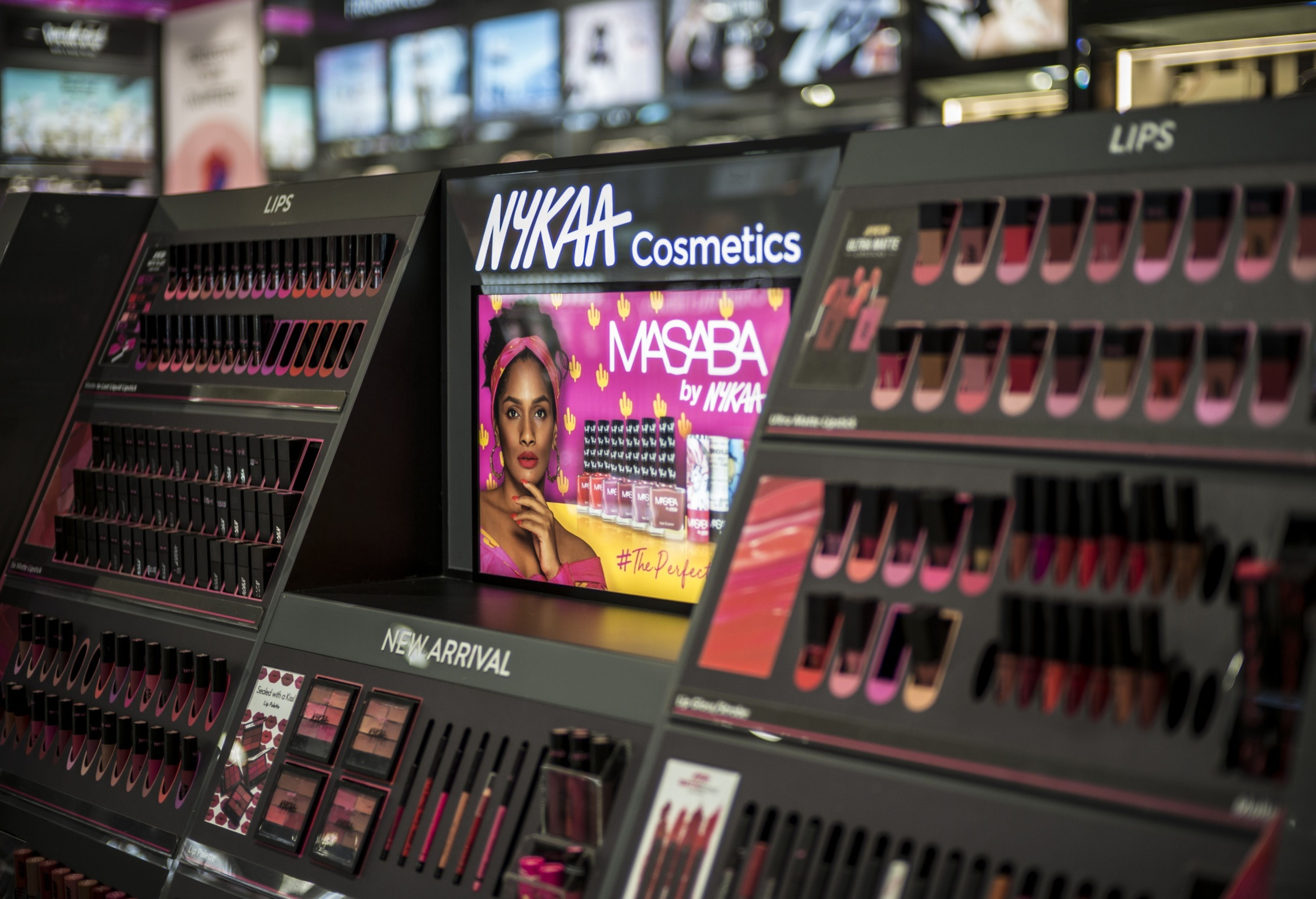 An aisle of lipsticks and eye shadows in a Nykaa store in India