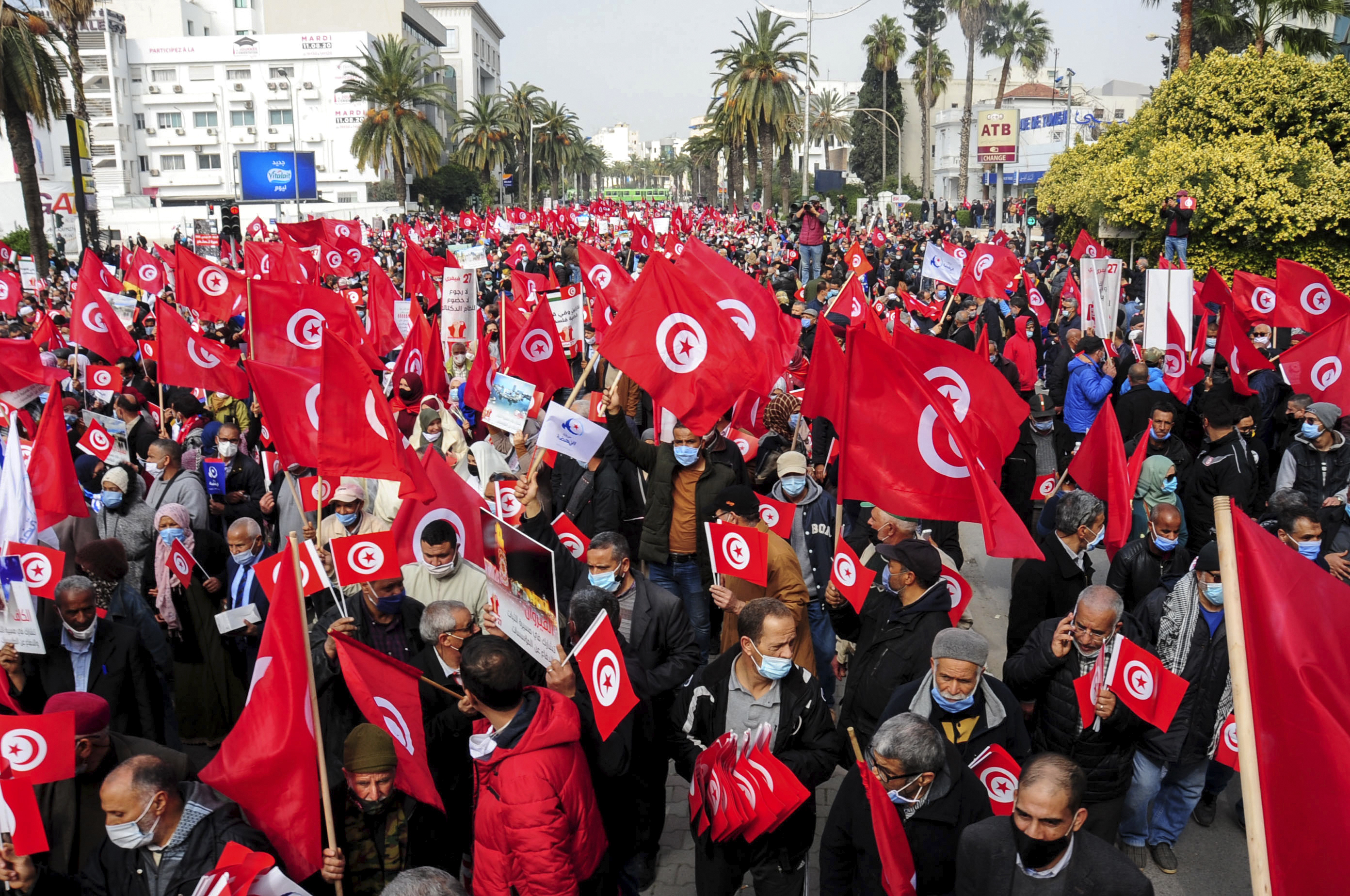 Supporters of the Ennada party march with Tunisian flags during a rally in Tunis [File: Hassene Dridi/AP Photo]