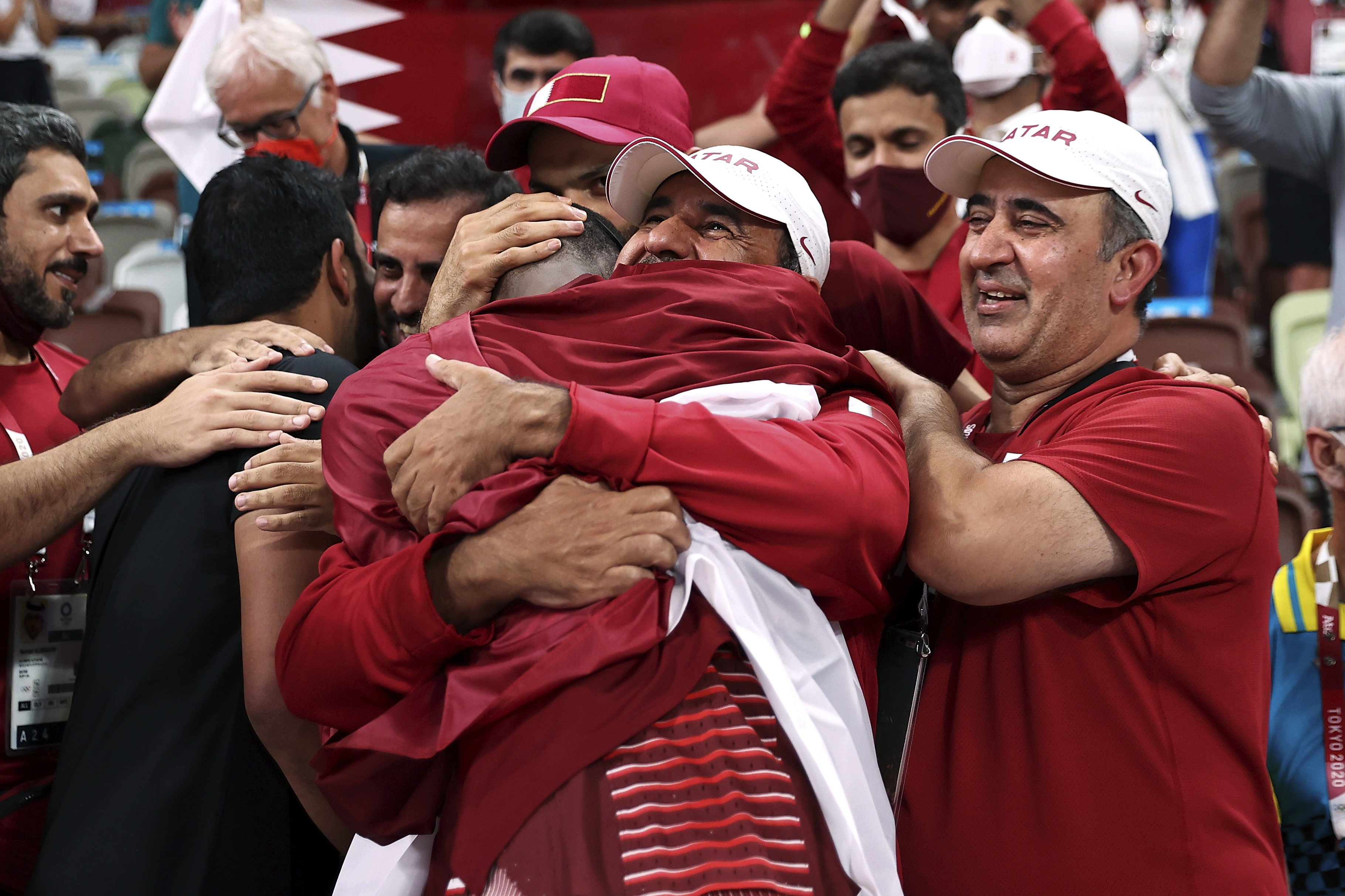 Gold medalist Barshim of Qatar celebrates with his team after winning (and sharing) gold in the men's high jump at the 2020 Olympics [Cameron Spencer/AP Photo]