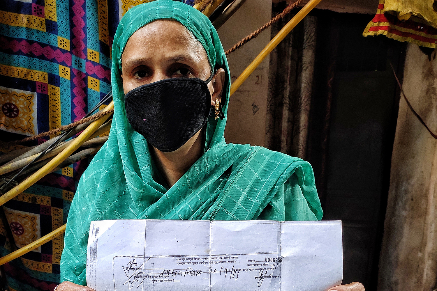 Tabassum Nisha holding her 2013 receipt of her application for a ration card [Srishti Jaswal/Al Jazeera]