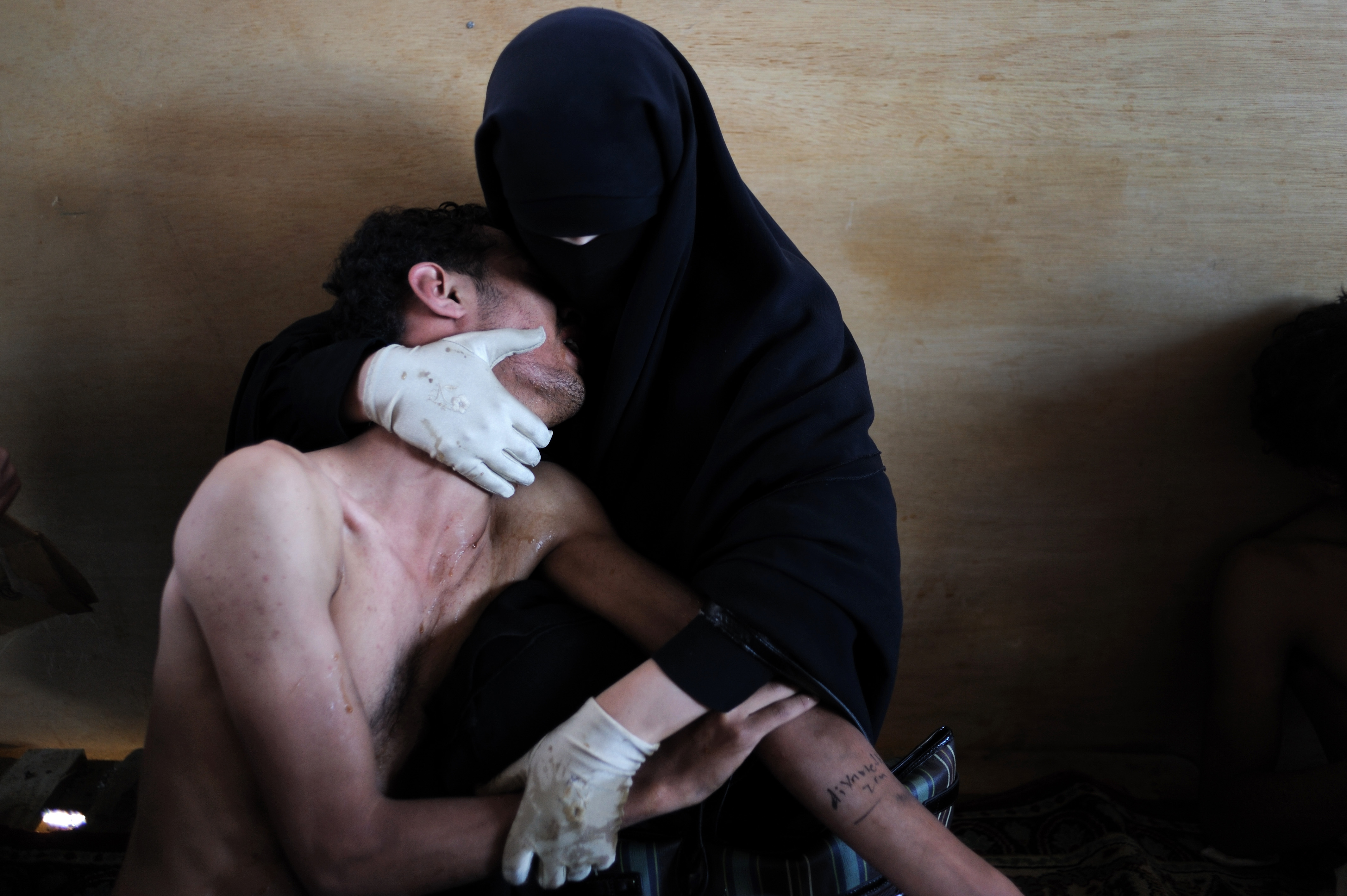 Fatima al-Qaws hugs her wounded son, Zayed, inside a mosque used as a field hospital by anti-government demonstrators in Sanaa, Yemen, on October 15, 2011. This photo won the World Press Photo award in 2012 [File:Samuel Aranda/The New York Times]