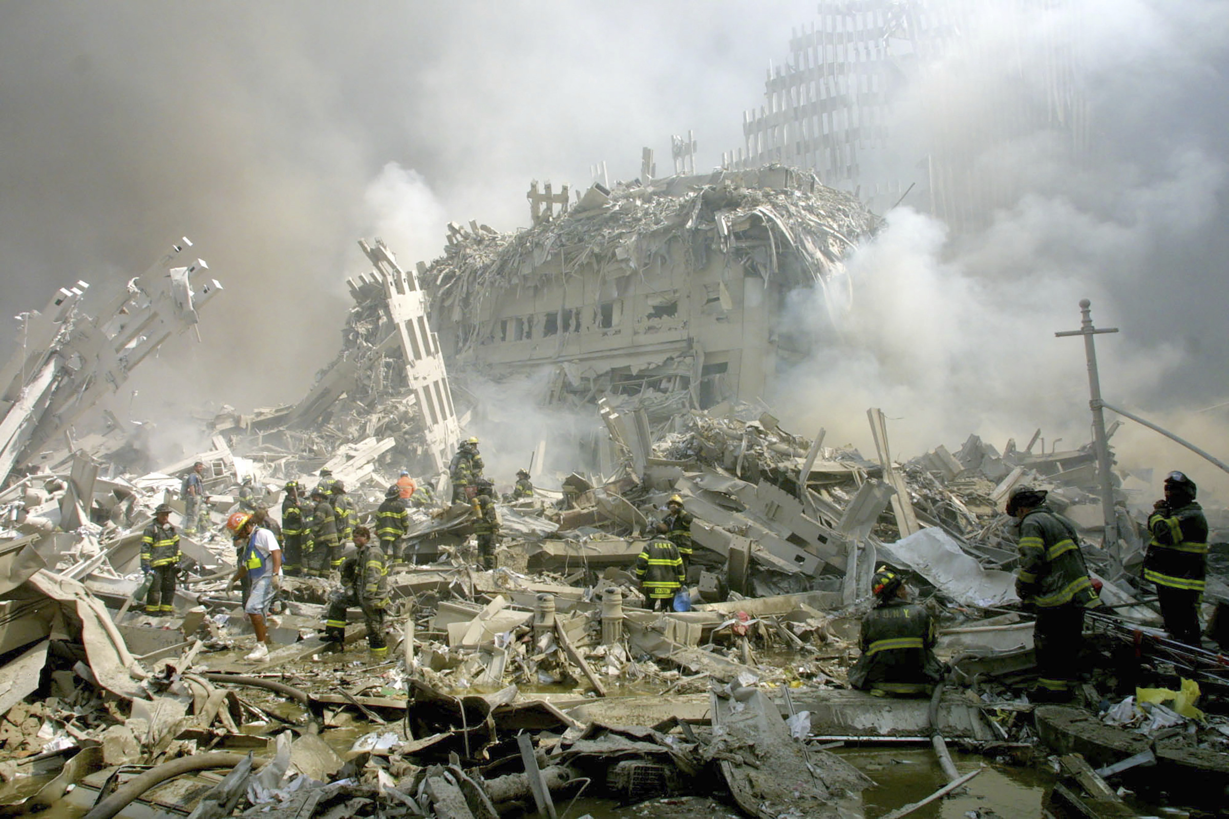 Firefighters make their way through the rubble after two hijacked airliners were crashed into the World Trade Center, bringing down the twin 110-storey towers in New York Tuesday, September 11, 2001 [Shawn Baldwin/AP Photo]