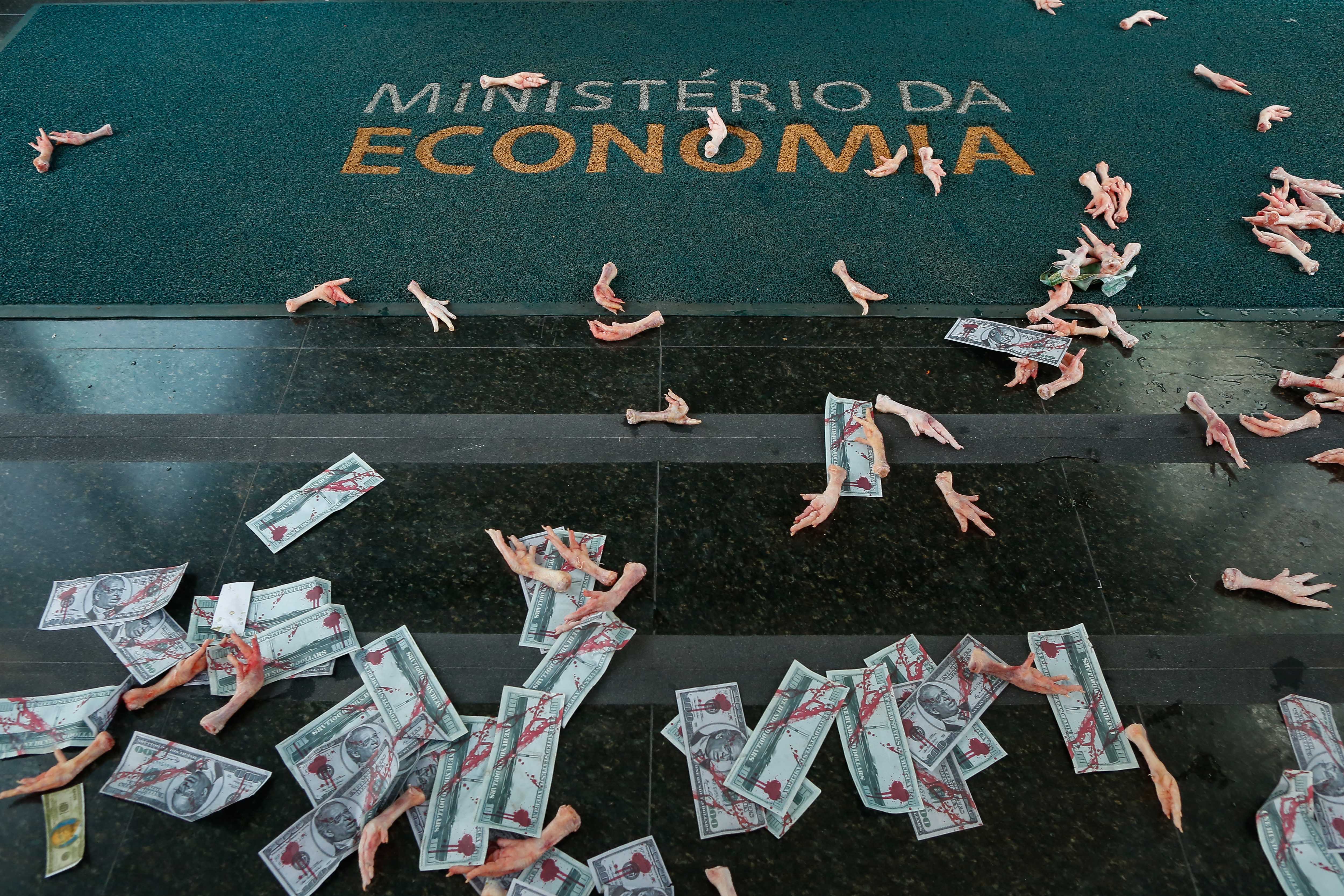Fake notes tainted in red and poultry feet are seen after a protest against Brazilian economy minister Paulo Guedes following Pandora Papers revelations about his offshore accounts, at the economy ministry in Brasilia on October 7 [AFP/Sergio Lima]