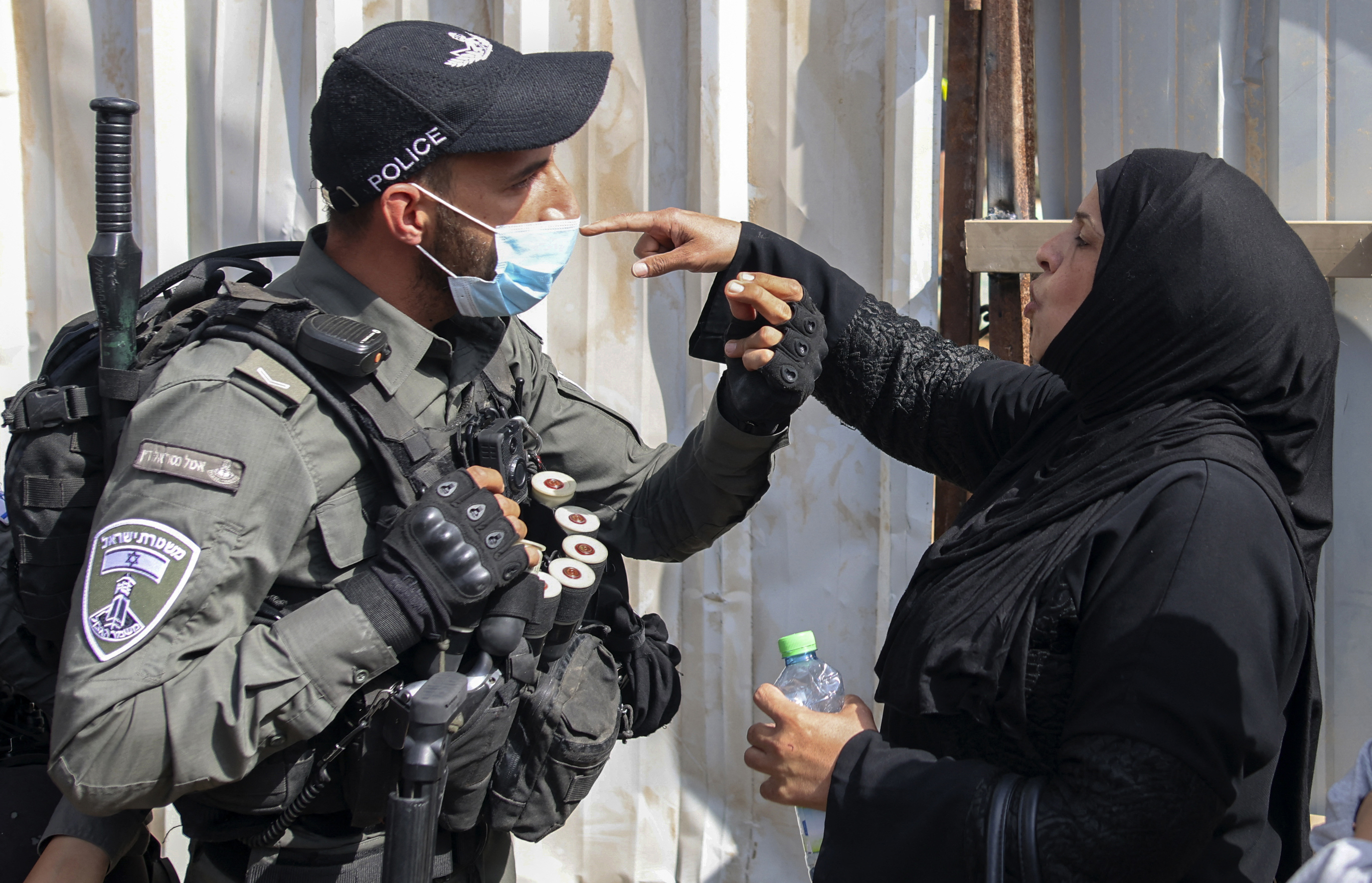 A Palestinian woman confronts Israeli army officers at the Al-Yousufiya Cemetery near the Lion's Gate entrance to the Al-Aqsa Mosque compound in East Jerusalem [Ahmad Gharabli/AFP]
