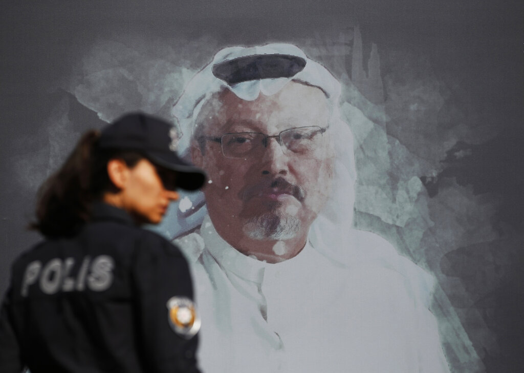 A Turkish police officer walks past a picture of slain Saudi journalist Jamal Khashoggi, near the Saudi Arabia consulate in Istanbul