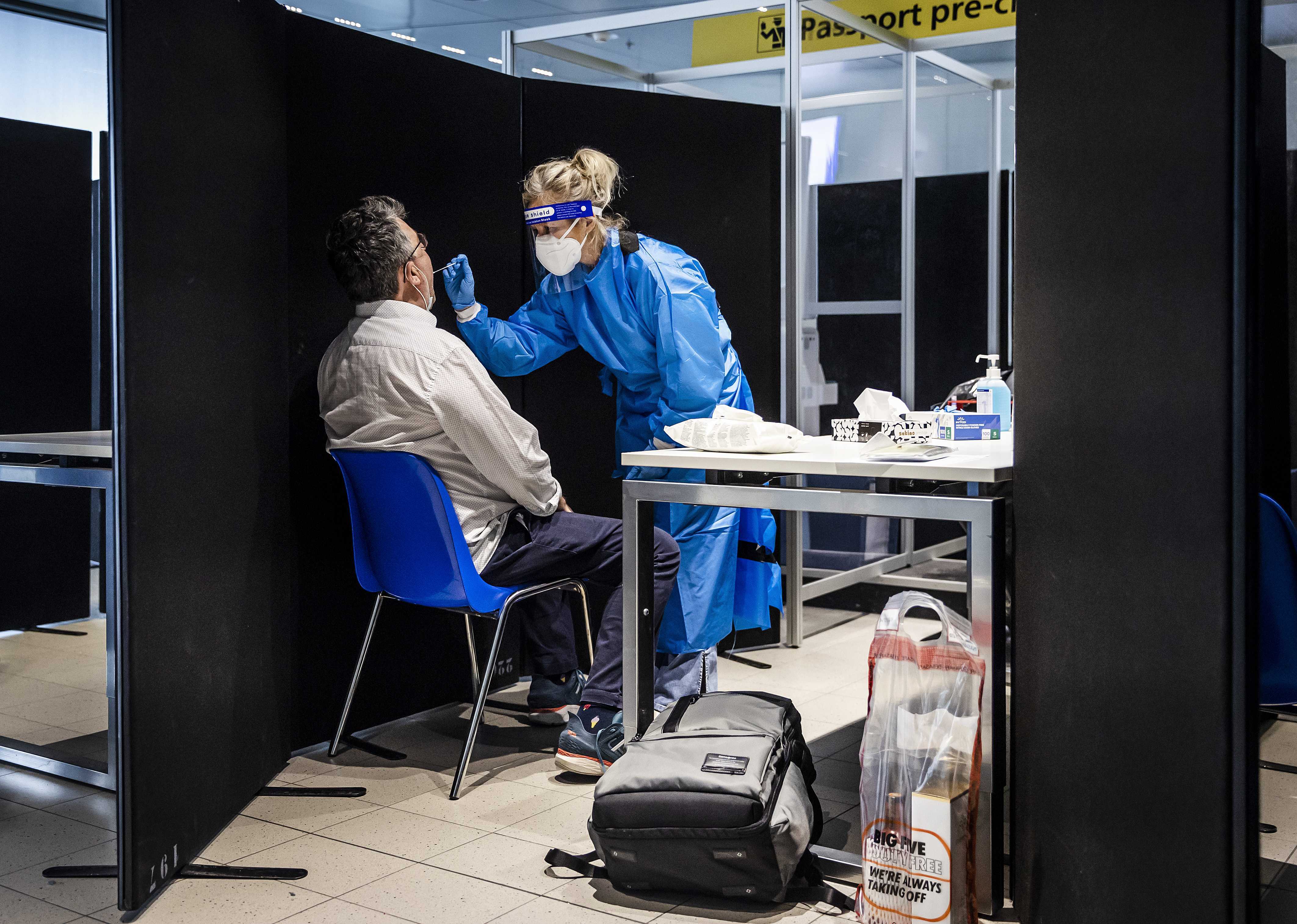 Travellers from South Africa are tested for the Coronavirus Omicron variant upon arrival in a specially designed test lane at the Schiphol airport, The Netherlands, 30 November 2021 [Remko De Waal/EPA]