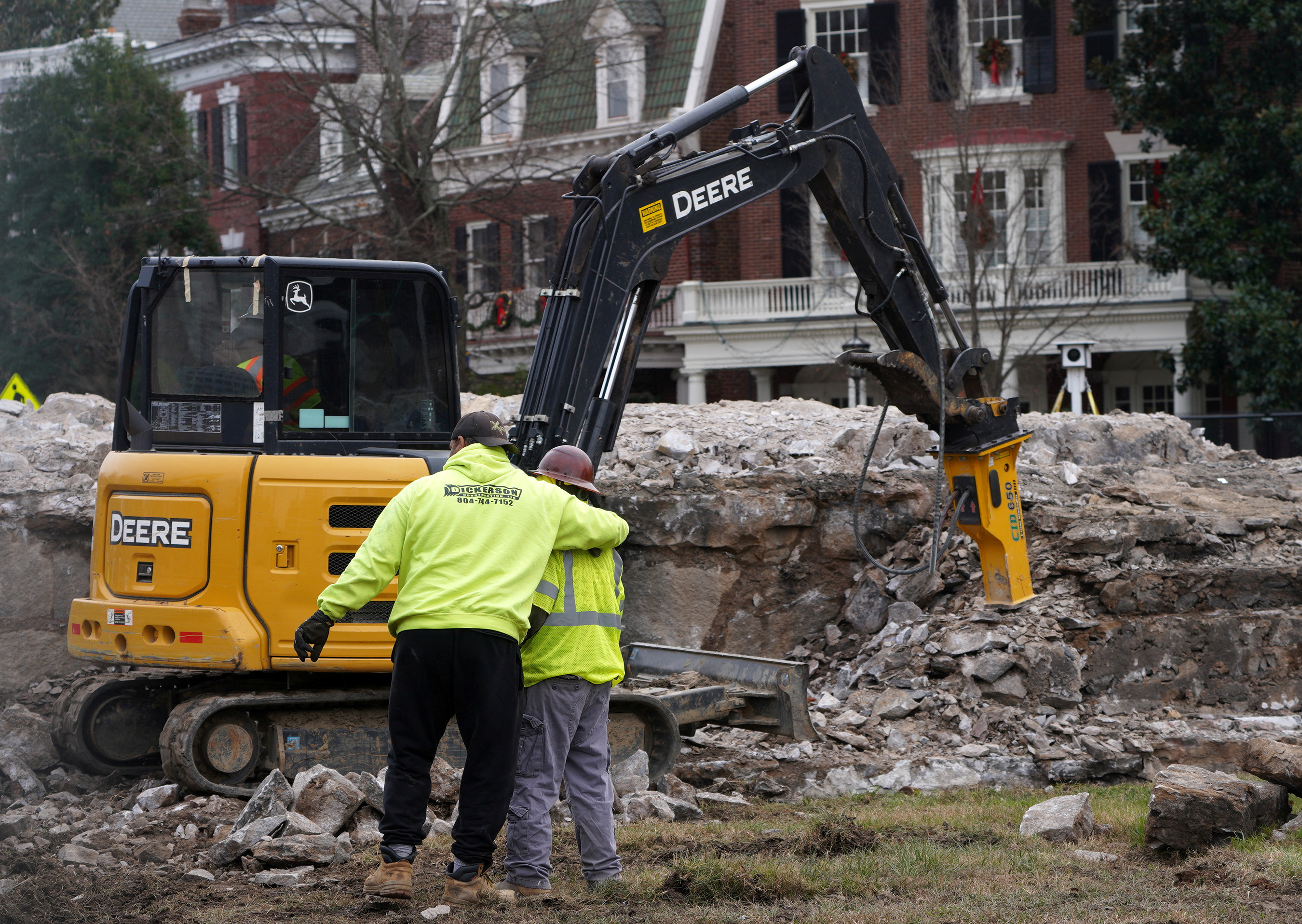 Workers react after an 1887 time capsule was removed from a former monument to Robert E Lee